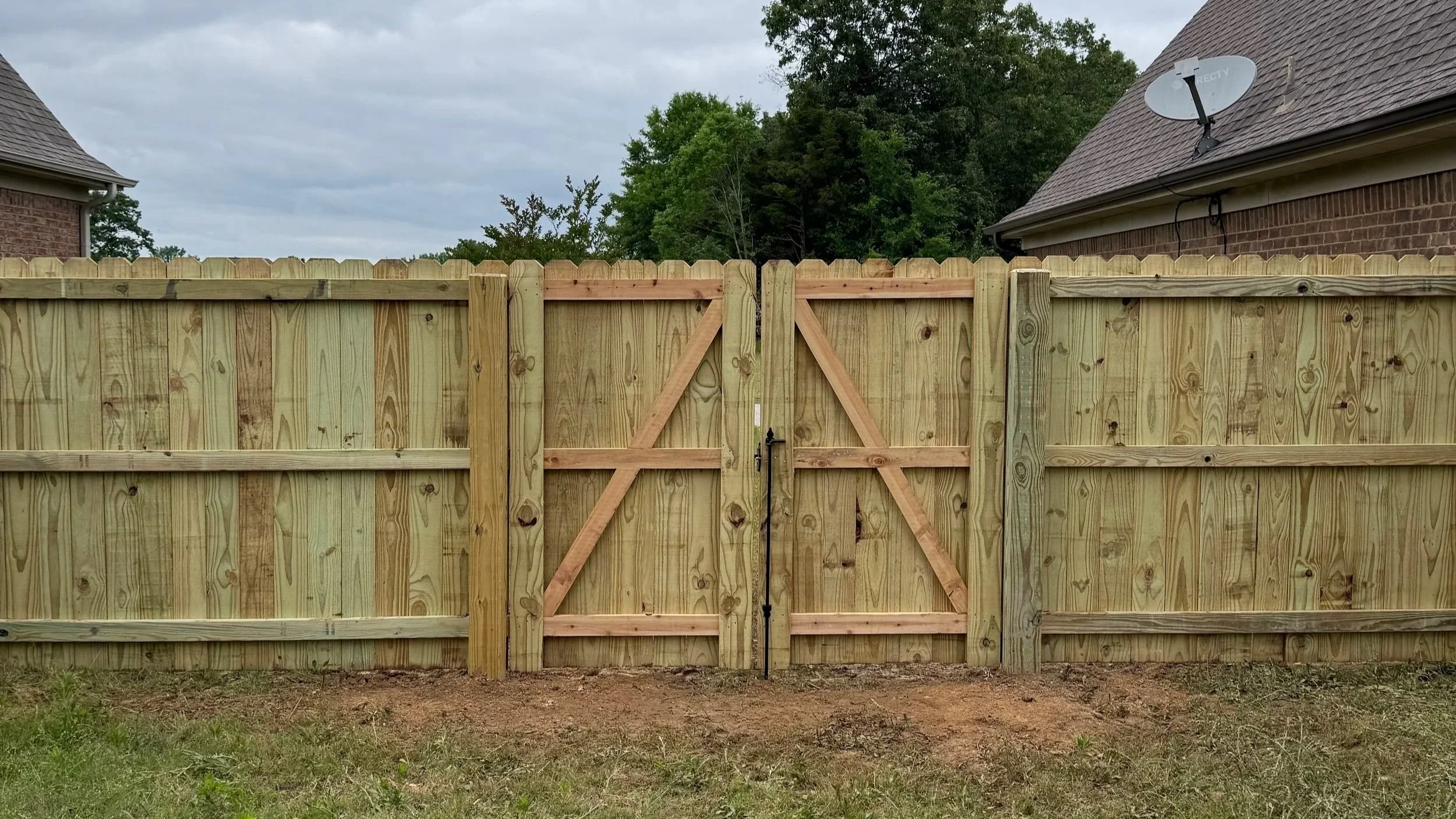 Custom cedar board double gate with pressure treated pine privacy fence installed by DeSoto Fence Co.
