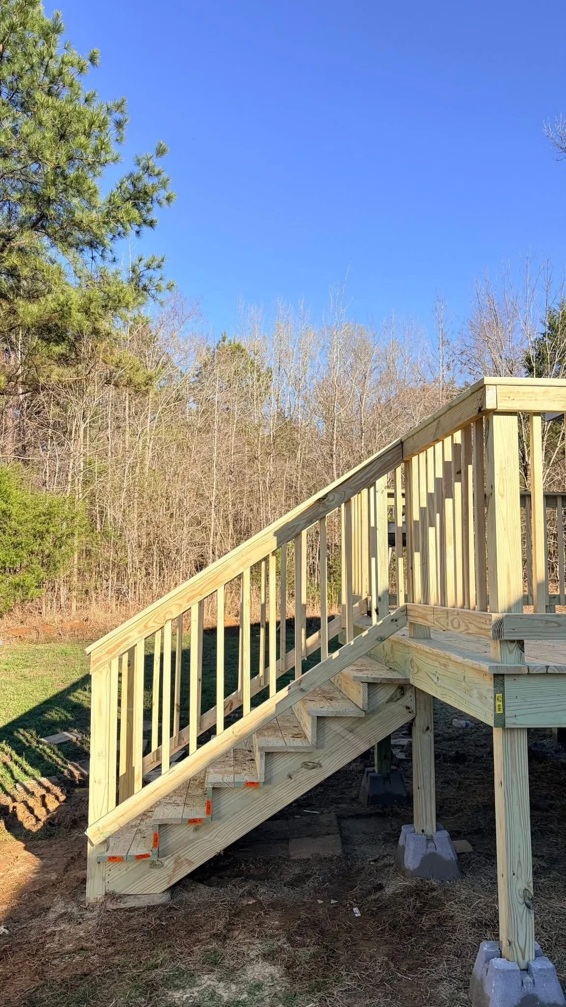 Pressure Treated Wood Deck in Hernando, Mississippi by DeSoto Fence Co. featuring custom stairs, elevated construction, and safety railings built to provide convenient access and functional outdoor living space.
