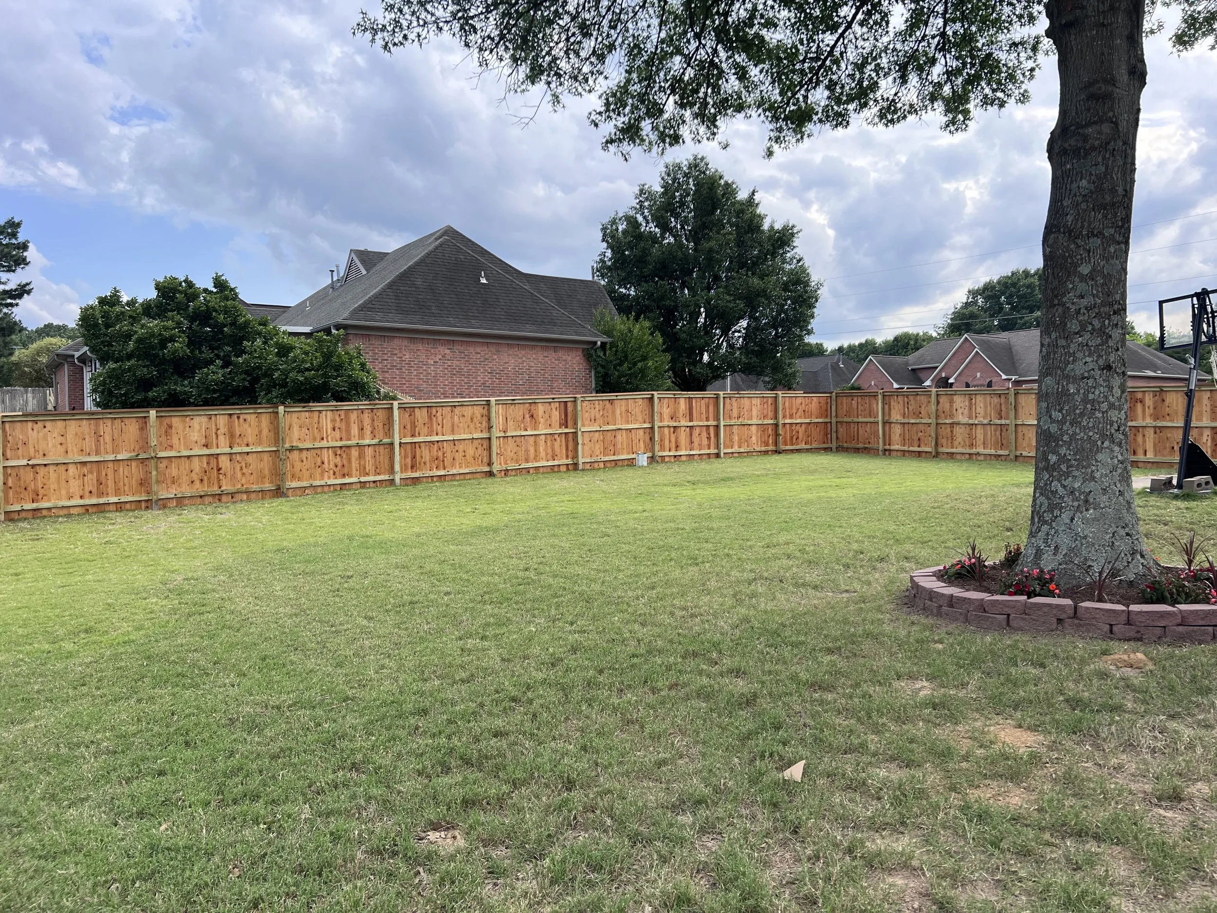 Water sealed cedar privacy fence with cedar cap and trim installed in Olive Branch, MS by DeSoto Fence Co.