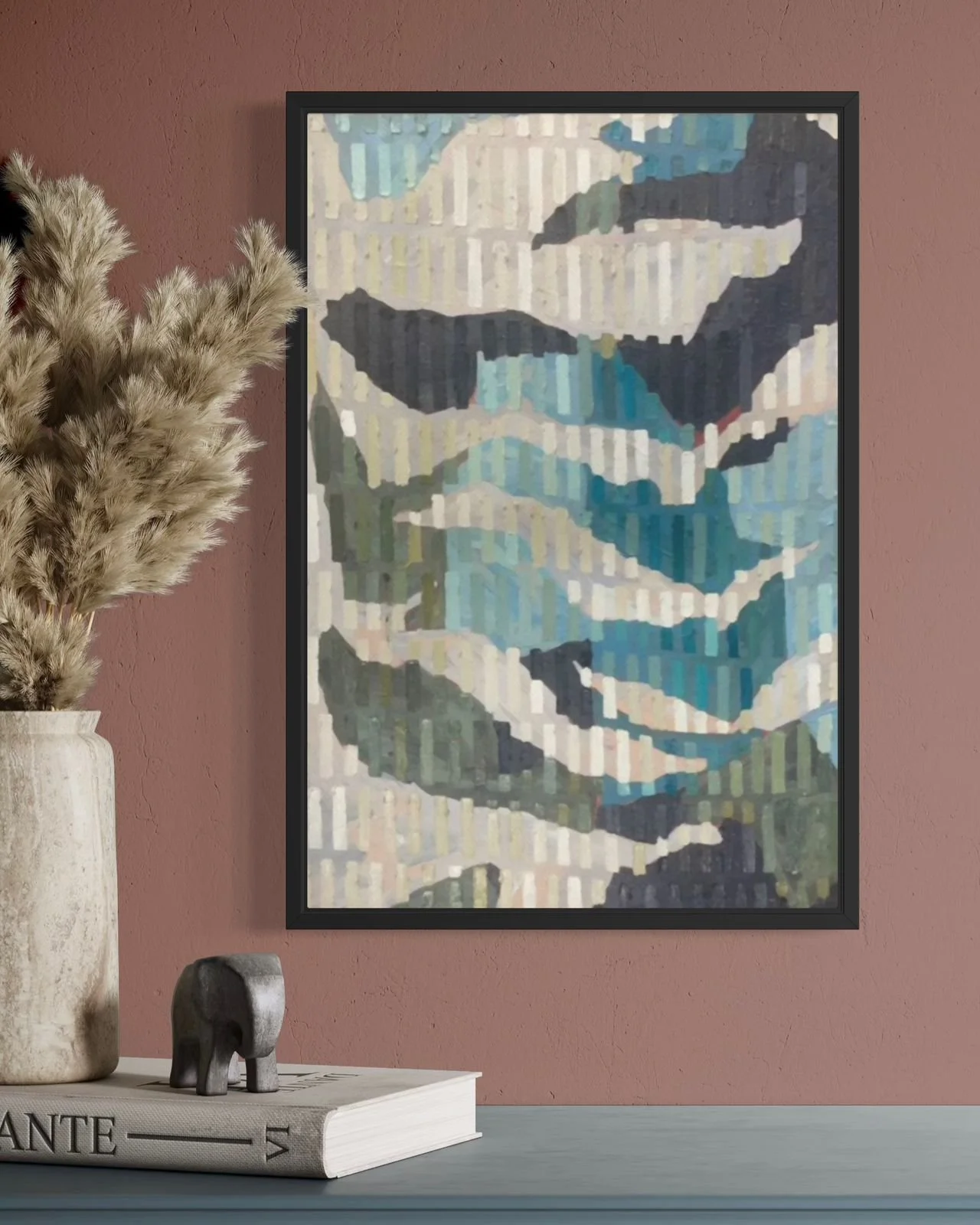 A decorative framed art print in artist Lili Dauphinee signature tic tac style. Abstract landscape painting in shades of blue, green, gray, and white, mounted on a pink wall, with a beige vase containing dried pampas grass on a white side table