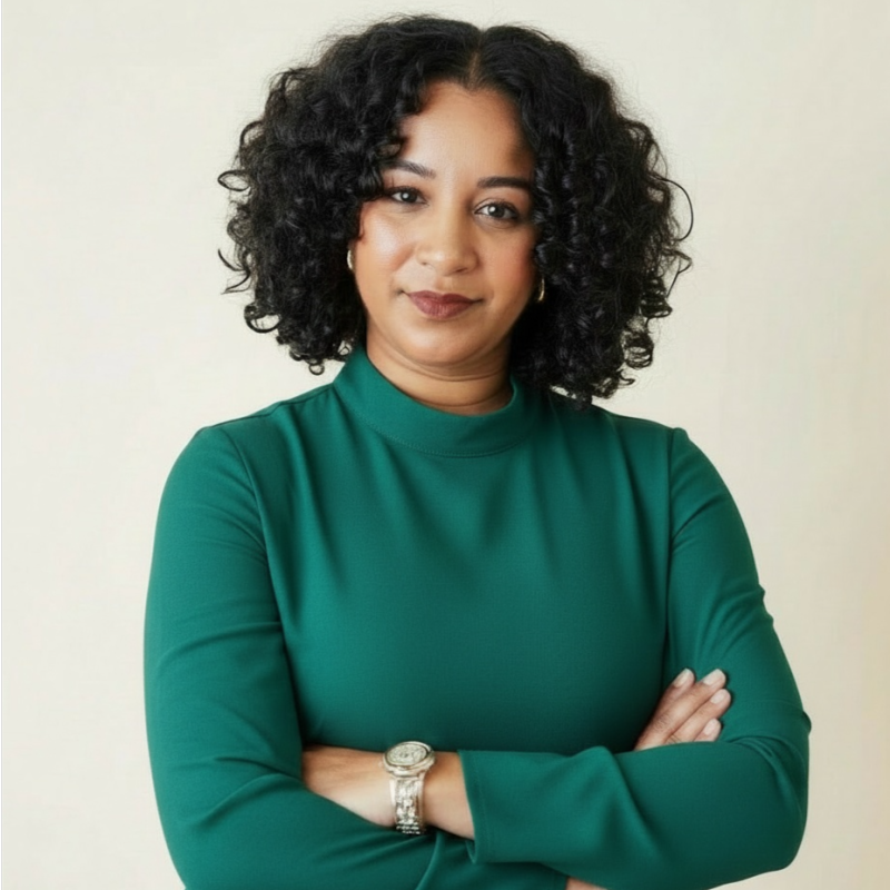 Picture of an AfroLatina woman with curly hair and a green turtleneck