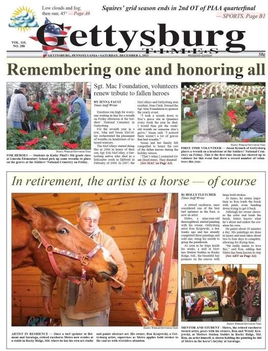The front page of a newspaper titled 'Gettysburg Times'. It features a headline about remembering and honoring fallen heroes with a photo of volunteers placing a wreath at a memorial, and an article about an artist in retirement painting a horse with accompanying images of the artist and her artwork.