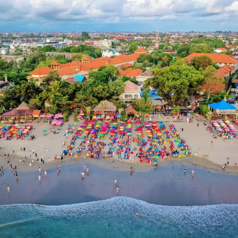 Ariel-Photo-Of-Bali-Seminyak-Beach-With-Colourful-Umbrellas-And-Tourists-Enjoying-Their-Holiday.jpg.webp
