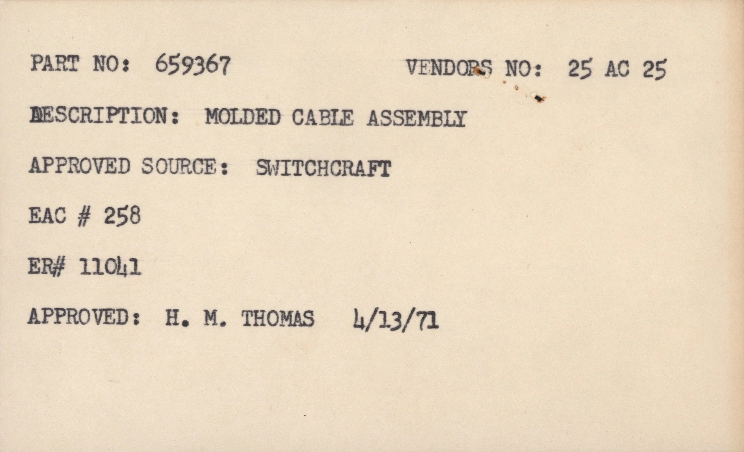 Close-up of a document with typed information, including part number 659367, vendor number 25 AC 25, description 'molded cable assembly,' and approval details, with some small dirt or ink spots on the paper.