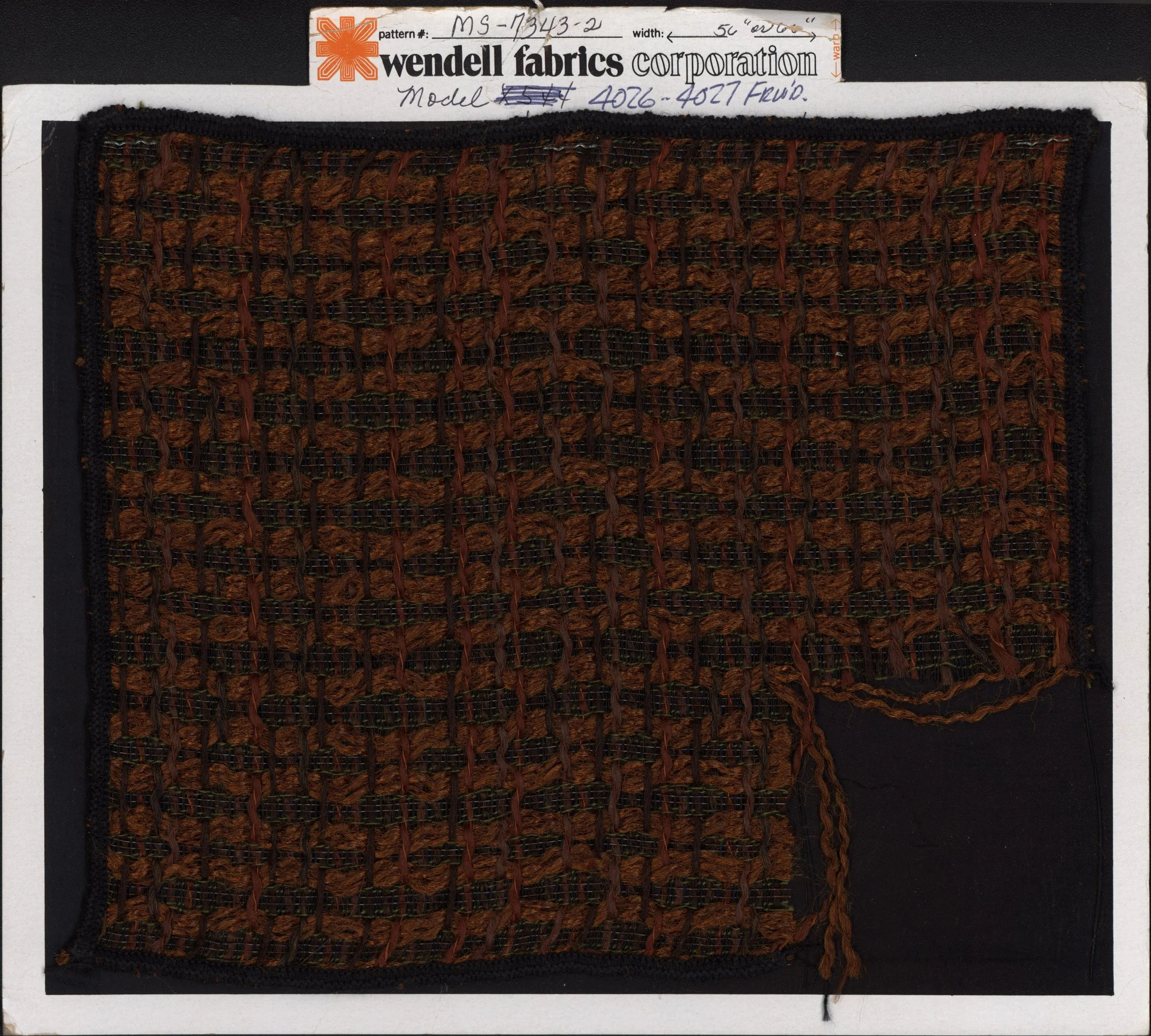 A fabric swatch attached to a display card from Wendell Fabrics Corporation, showing a pattern numbered MS-7343-2, in earthy brown and black colors.