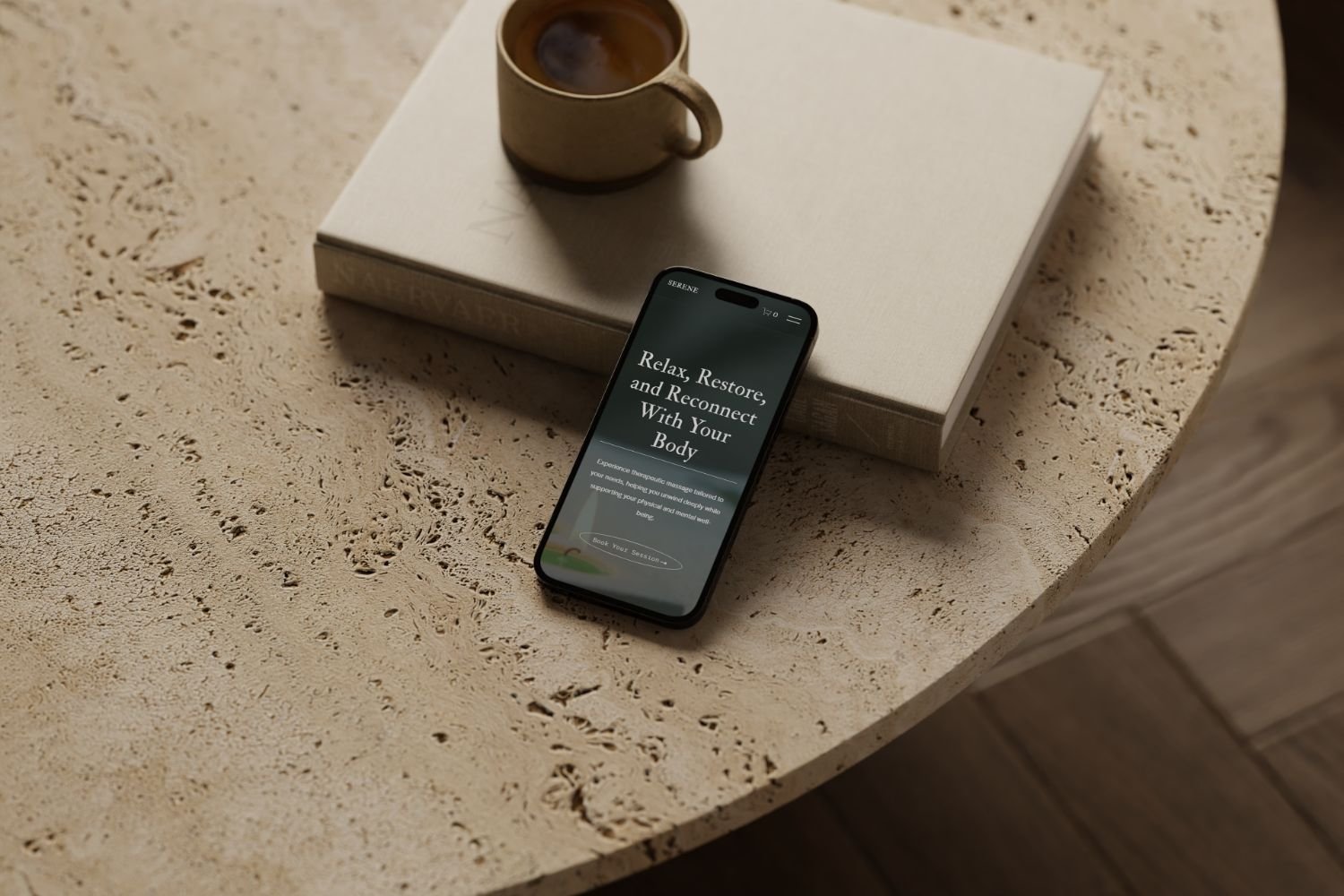 A coffee mug, a closed white book, and a smartphone displaying Serene, a wellness website designed by Bohora.