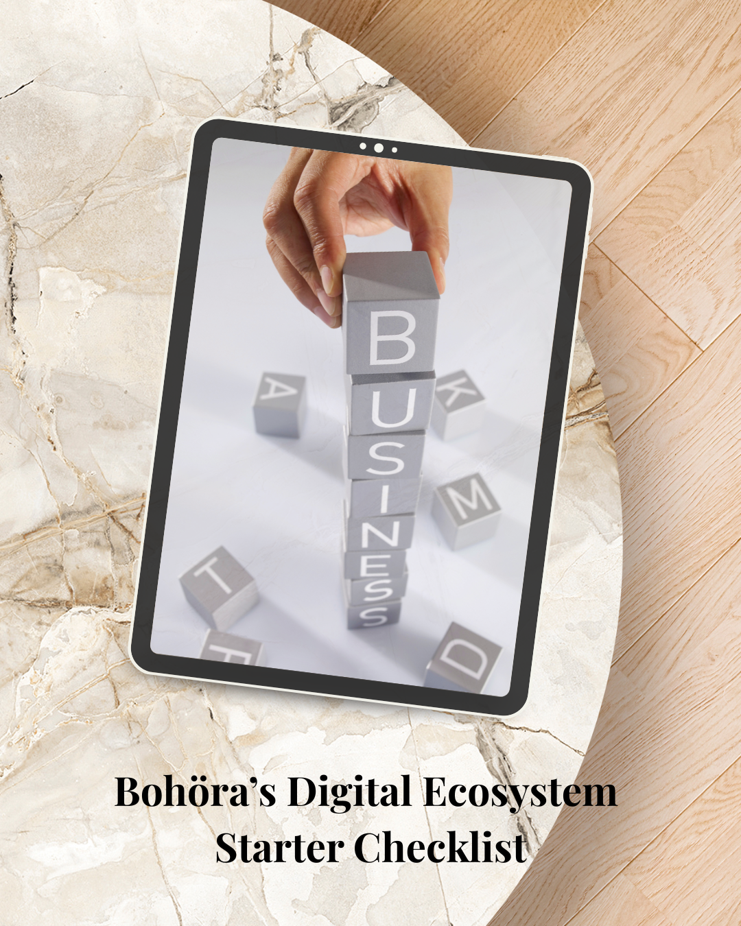 A tablet displays a hand stacking blocks labeled with words such as 'BUSINESS' and 'TEAM', with the background showing various letter blocks on a marble surface, and the text "Bohora’s Digital Ecosystem Starter Checklist" at the bottom.