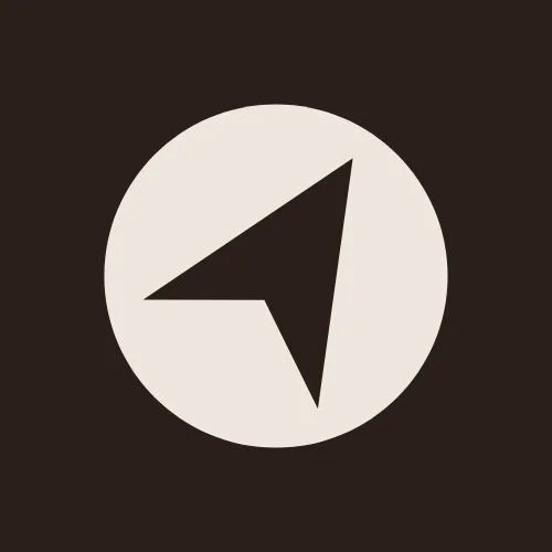 Icon of a black compass needle inside a white circle on a black background.