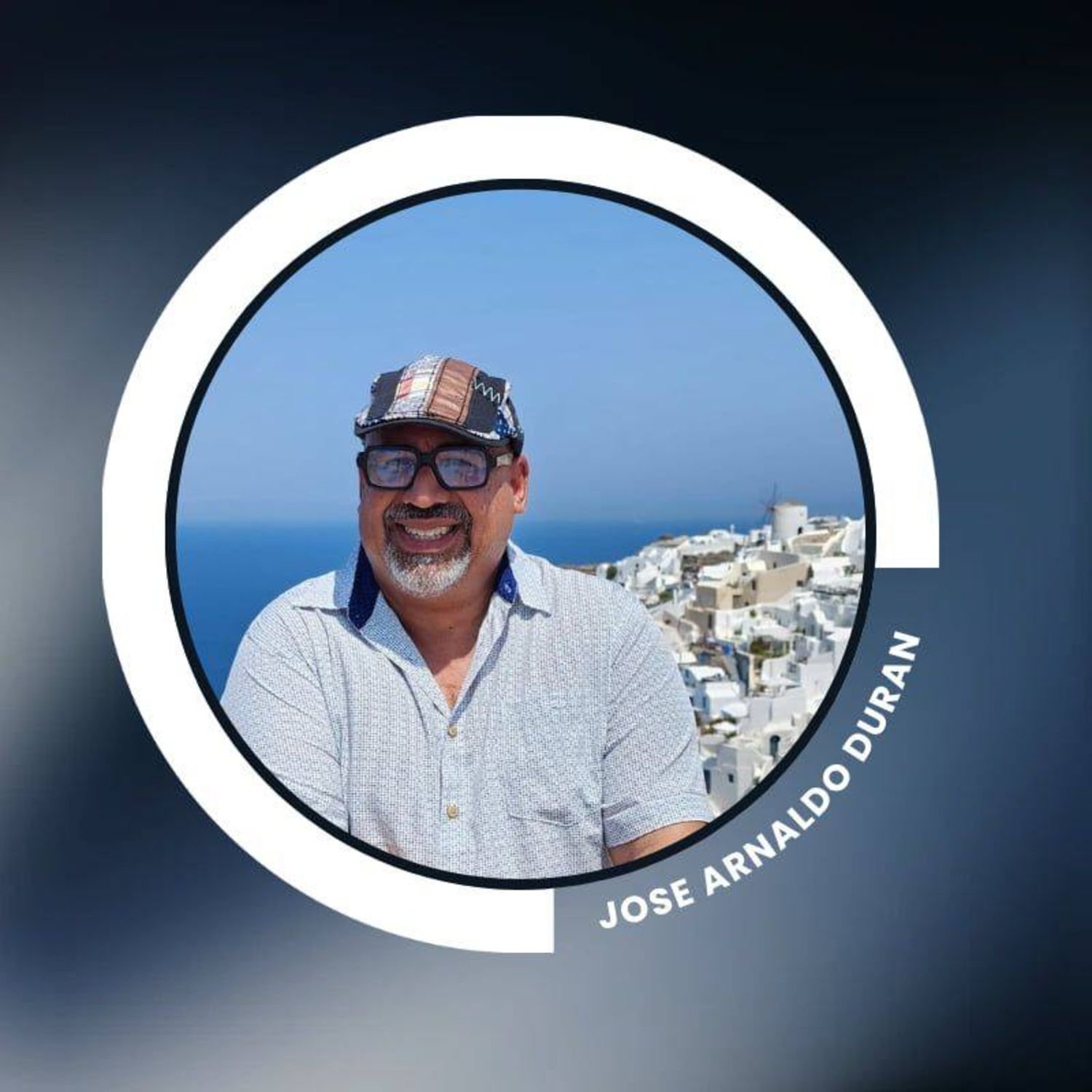 Photograph of a man wearing glasses and a patchwork hat, smiling, with a background of white buildings on a hillside and blue sky, labeled 'José Arnaldo Durán'.