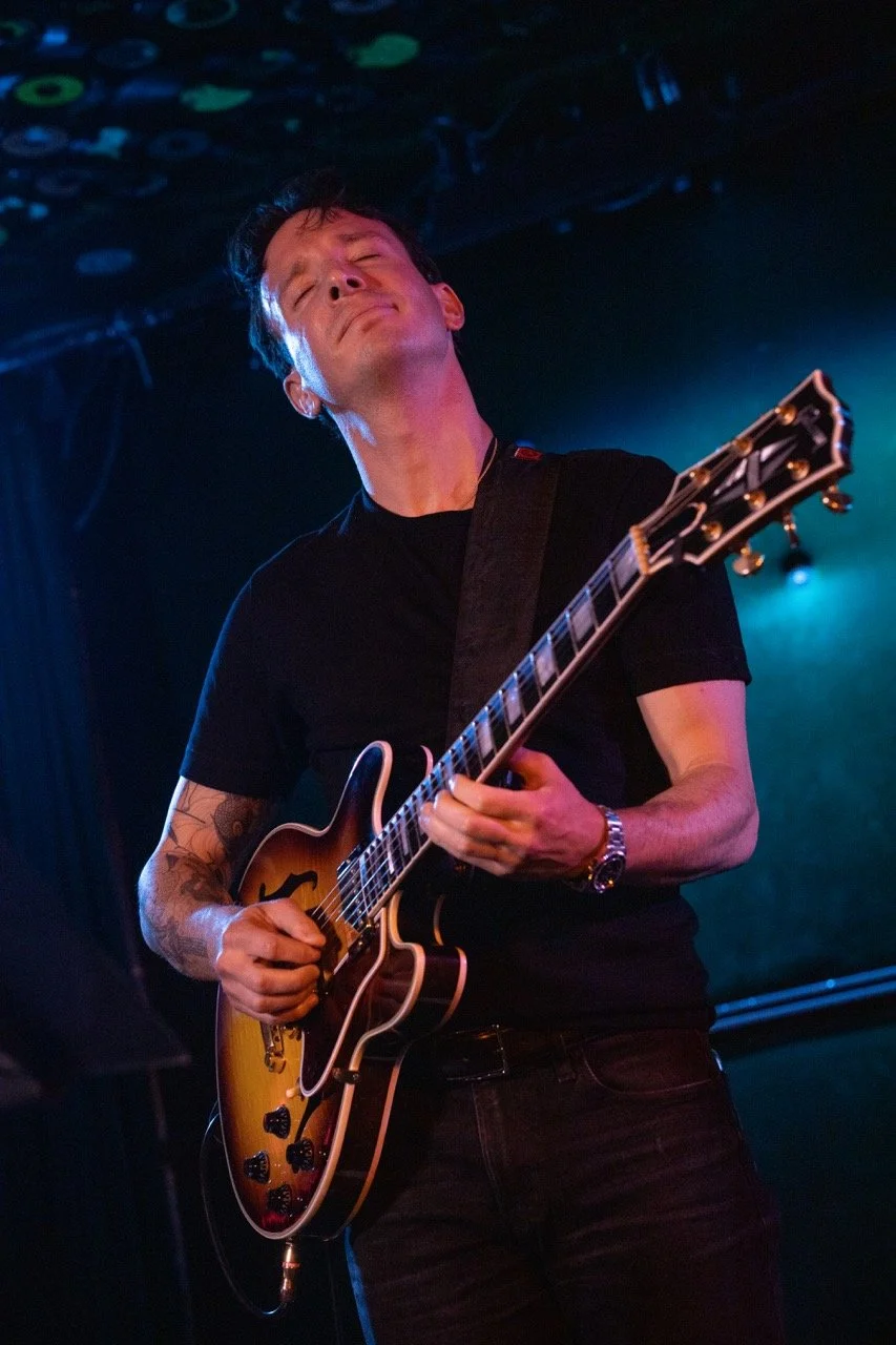 Guitarist onstage playing solo.