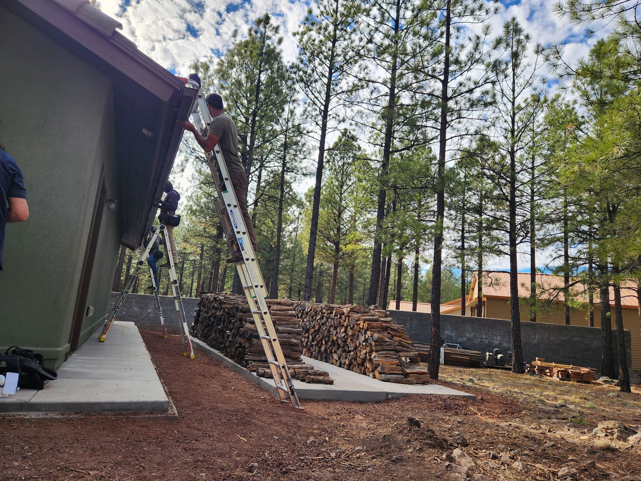 Guardian Gutters LLC installing custom seamless gutters in Flagstaff AZ with high pine tree coverage