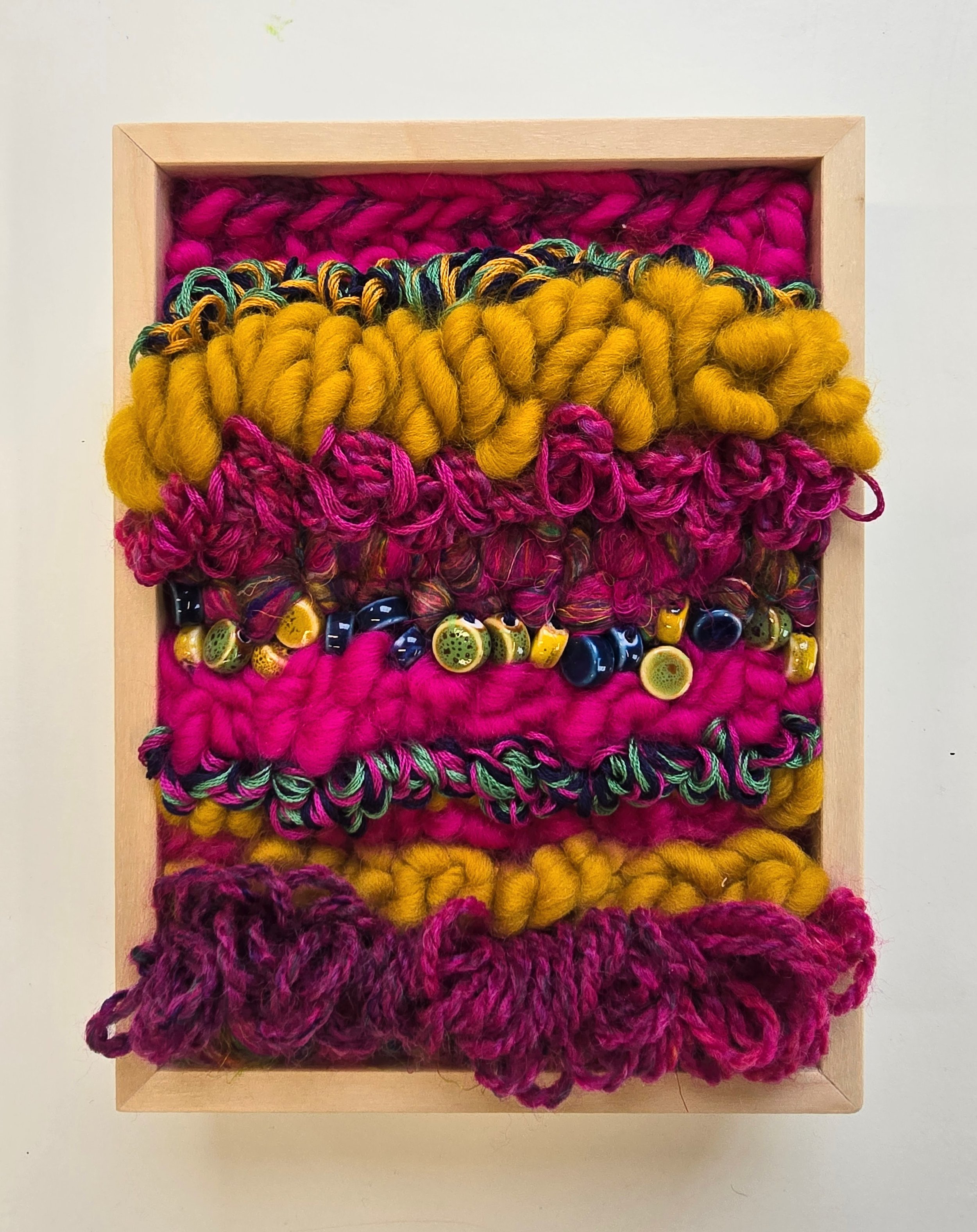 Magic Carpet Ride | Hooked wool and mixed yarns, stitched yarns, recycled sari silk, embroidery, & ceramic beading in a solid birch frame with natural finish | 6” x 8” x 2” |  $175

