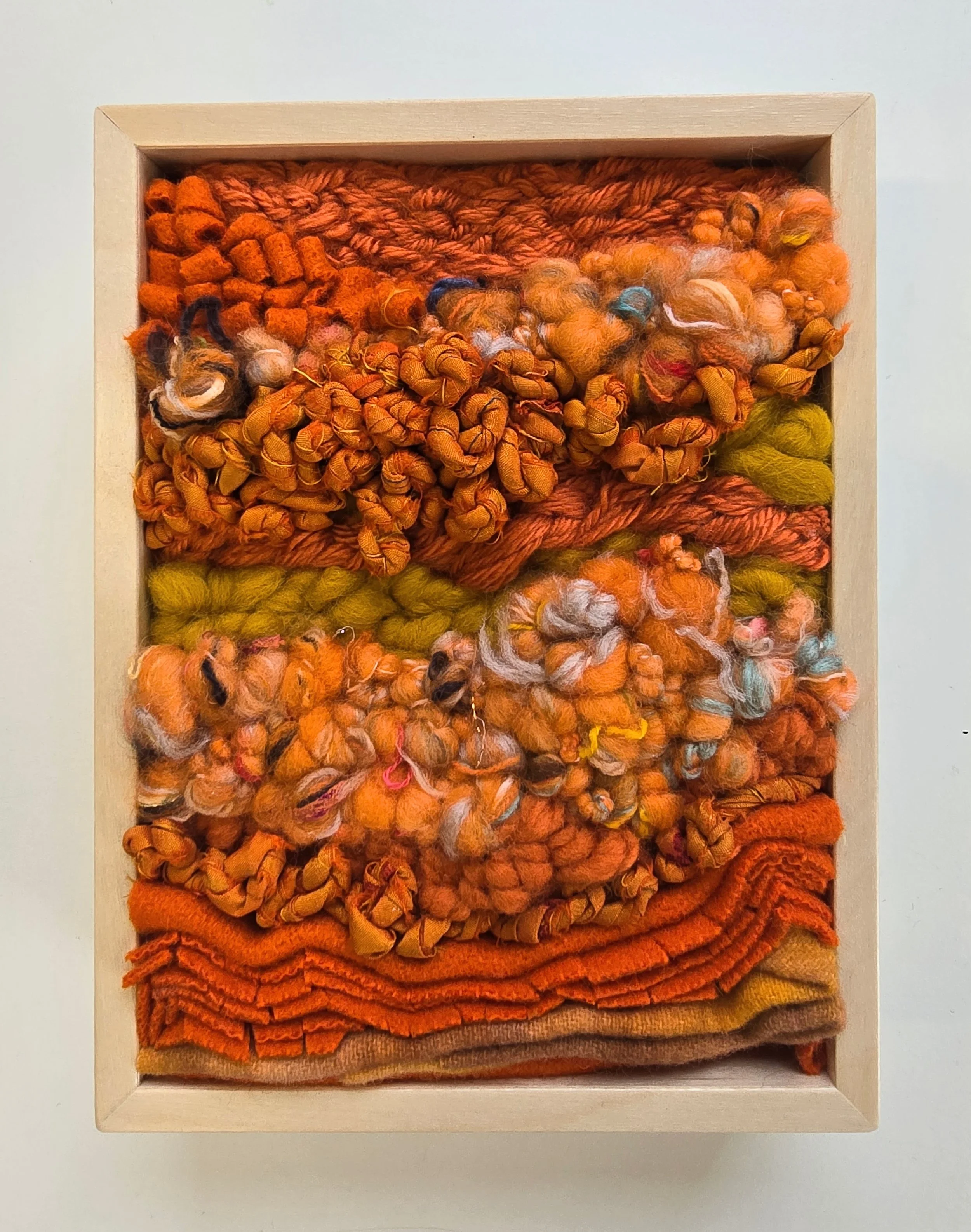Orange Crush | Hooked wool and mixed yarns, handspun art yarn, wool felt, & recycled sari silk, in a solid birch frame with natural finish | 6” x 8” x 2” | $175
