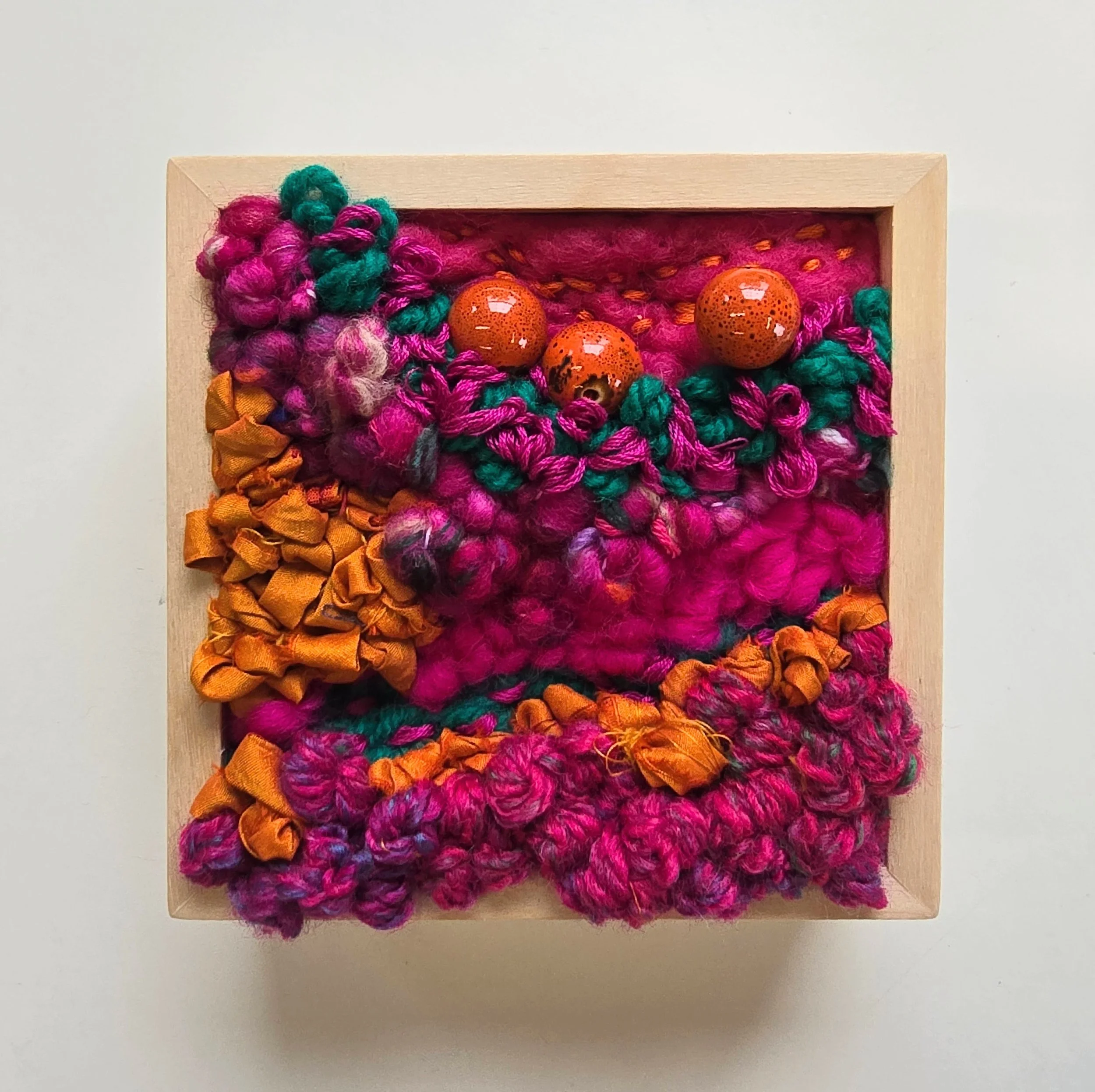 I Love You Sideways | Needle felted wool, hooked wool, handspun art yarn, stitched yarns, recycled sari silk, embroidery, & ceramic beading in a solid birch frame with natural finish | 5” x 5” x 2” | $125
