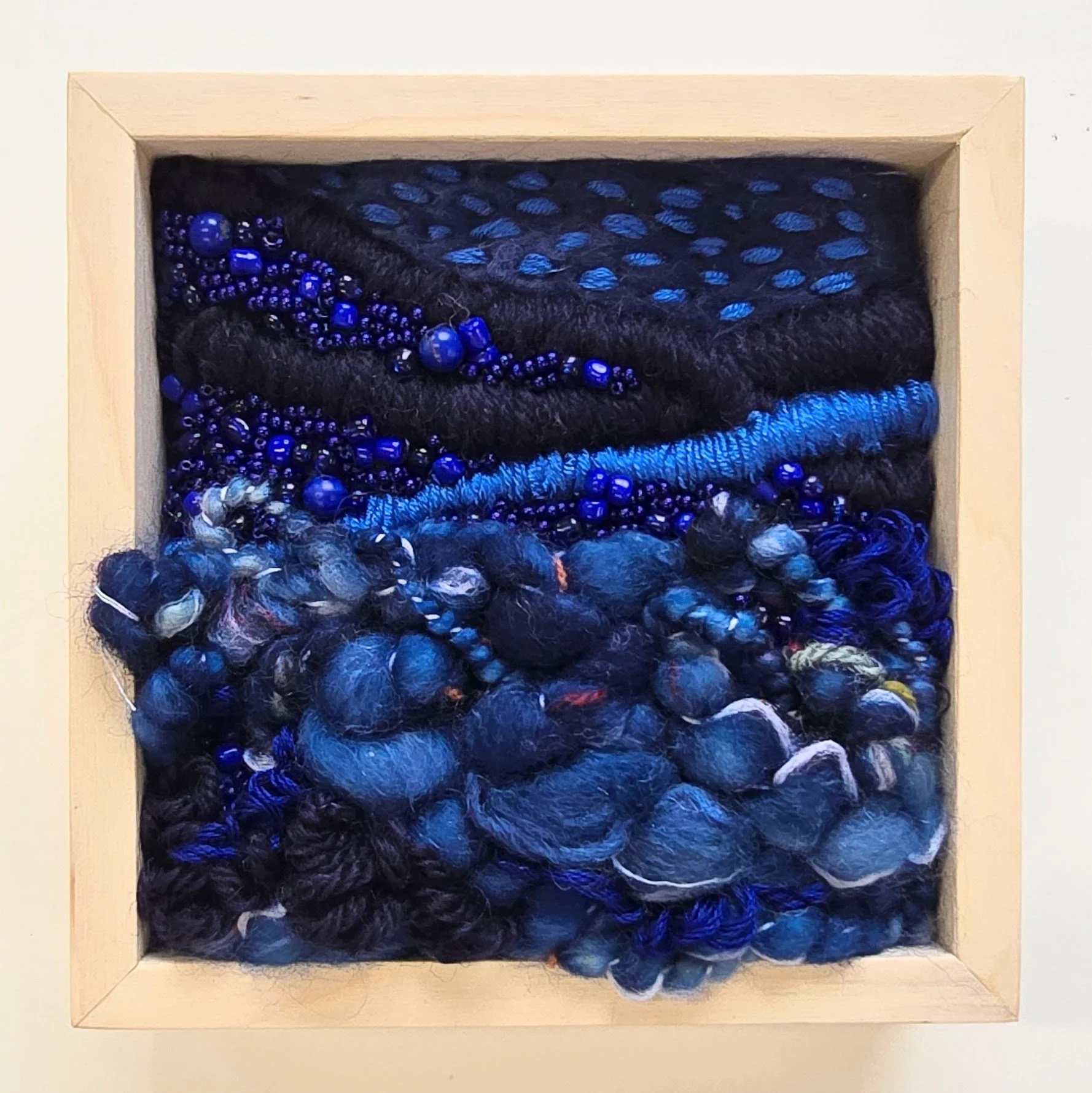 Deep Blue Sea | Needle felted wool, handspun art yarn, mixed yarns, stitching, & stone & glass beads in a solid birch frame with natural finish | 5" x 5" x 2" | SOLD
