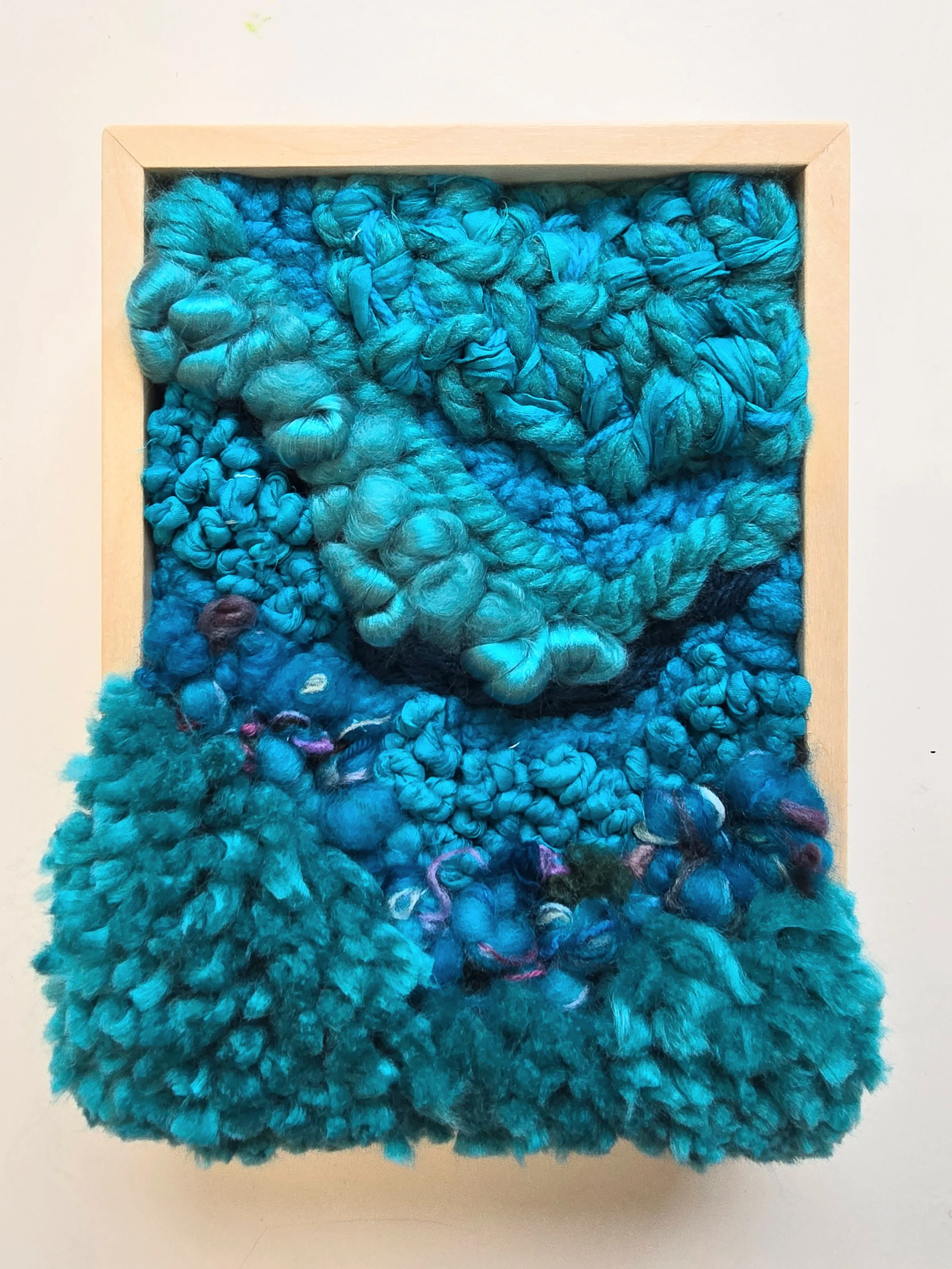 Into The Deep | Hooked wool and mixed yarns, handspun art yarn, wool roving, and recycled sari silk, in a solid birch frame with natural finish | 6” x 8” x 2” | $175
