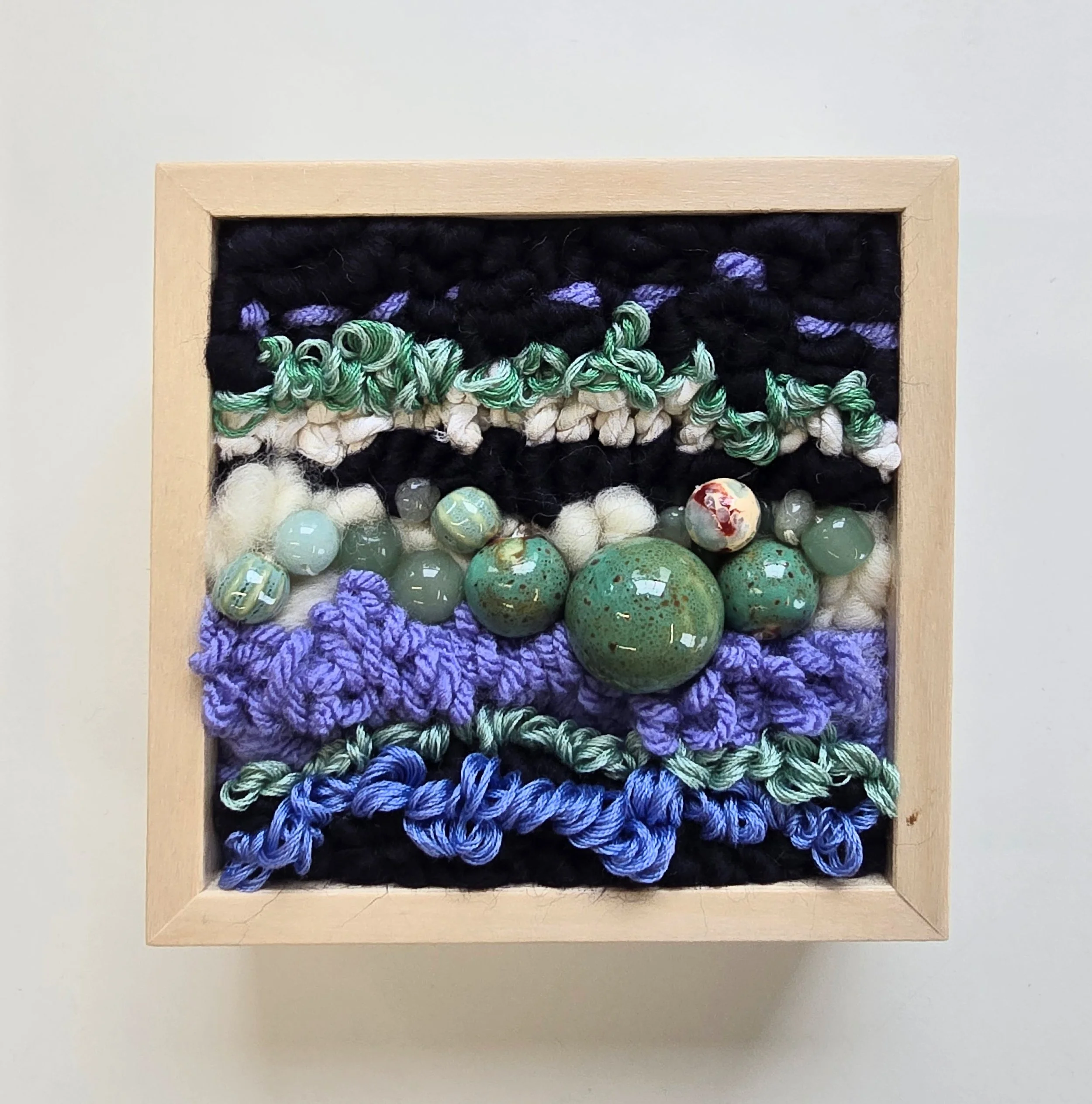 Odd Man Out | Hooked wool, handspun art yarn, mixed yarns, stitching, & ceramic beads in a solid birch frame with natural finish | 5” x 5” x 2” | $125

