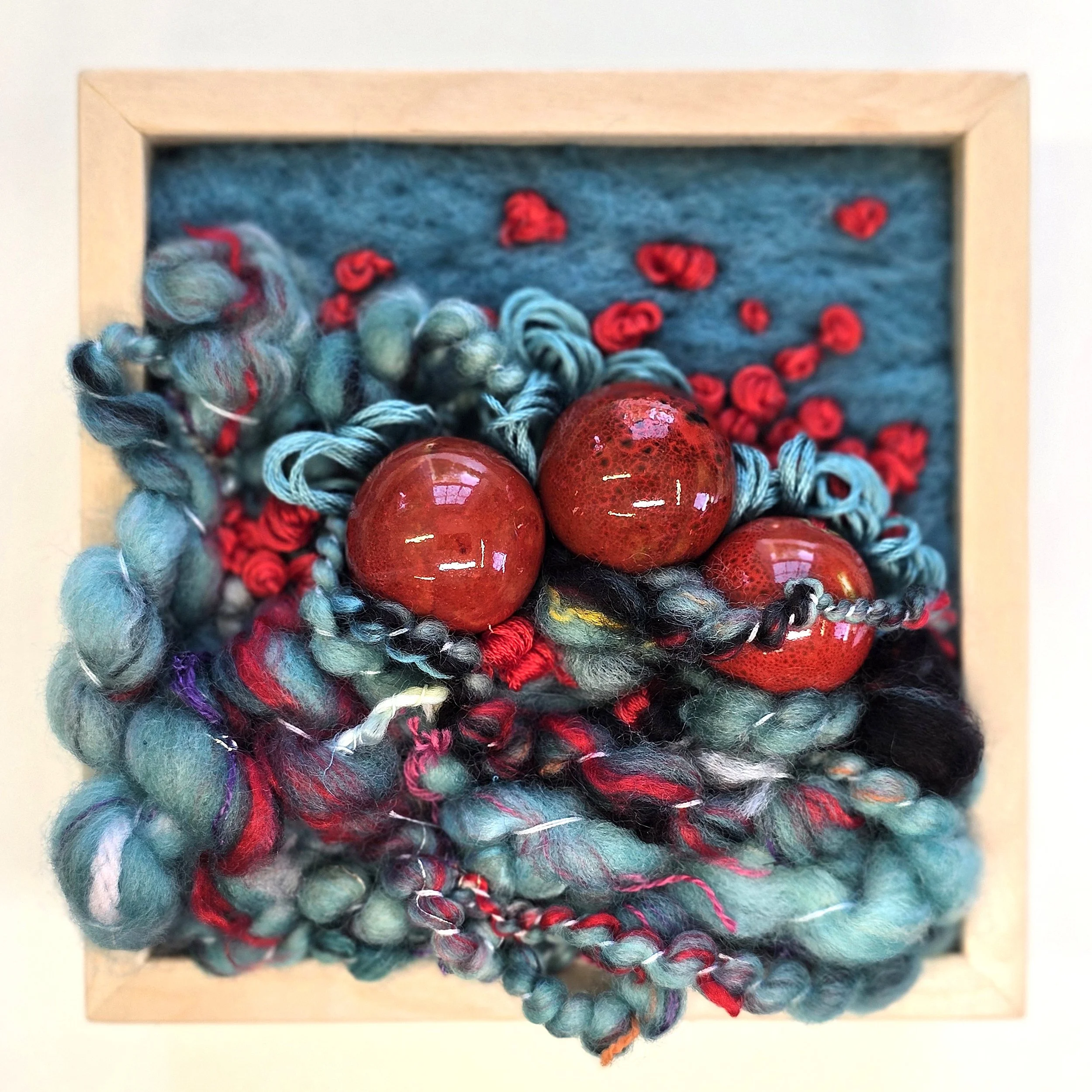Red Tide | Needle felted wool, handspun art yarn, stitching, & ceramic beads in a solid birch frame with natural finish | 5" x 5" x 2" | SOLD
