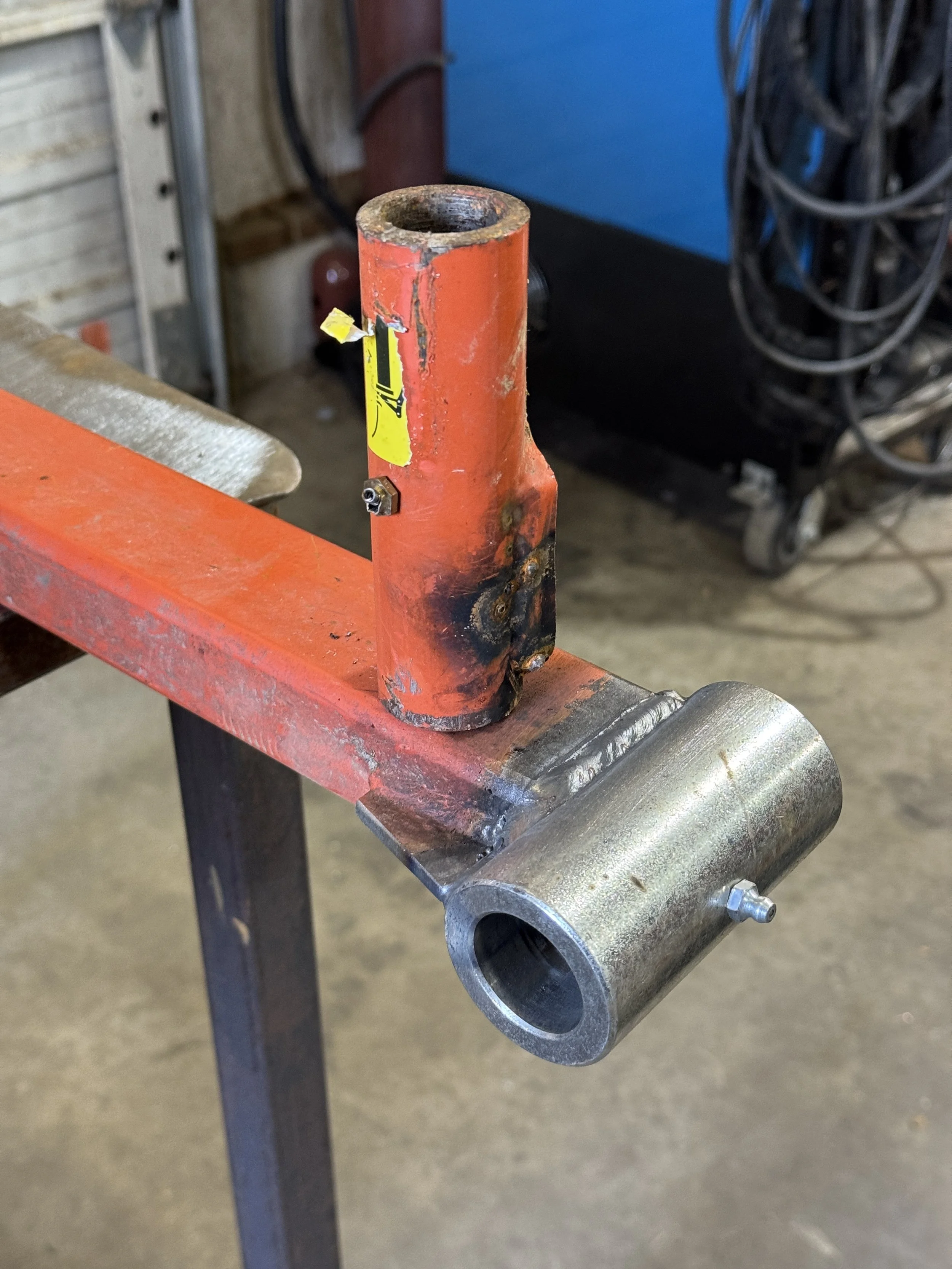 Broken brush hog tail wheel assembly with failed spindle before repair at McCarty Fabrication.