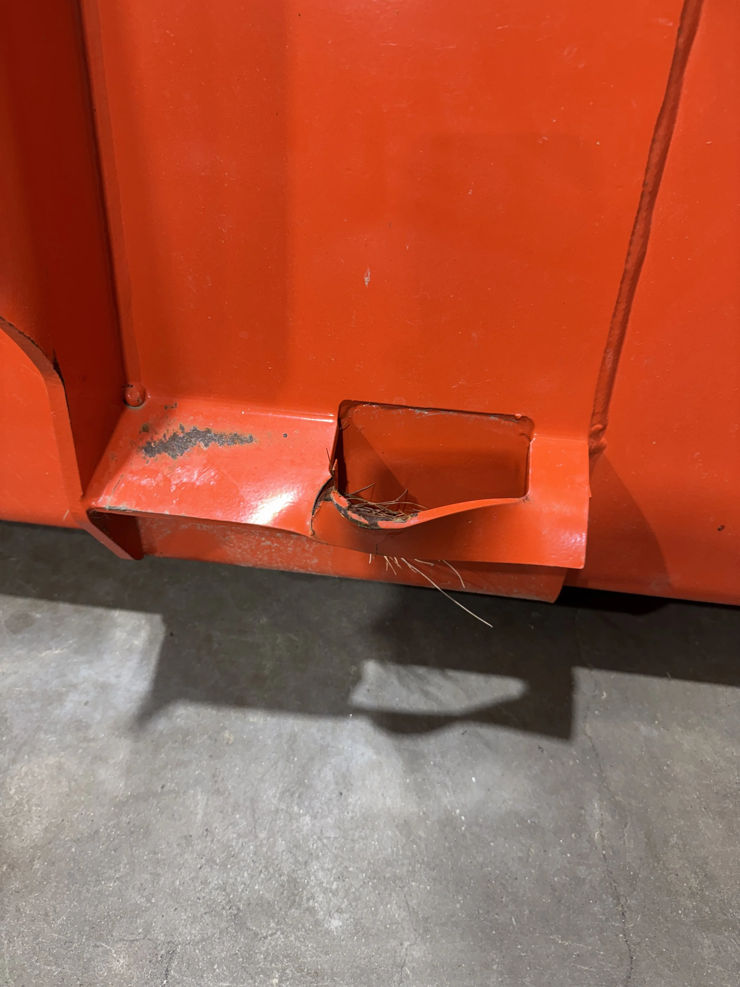 Damaged tractor bucket with torn steel and bent edge before welding repair in London Kentucky