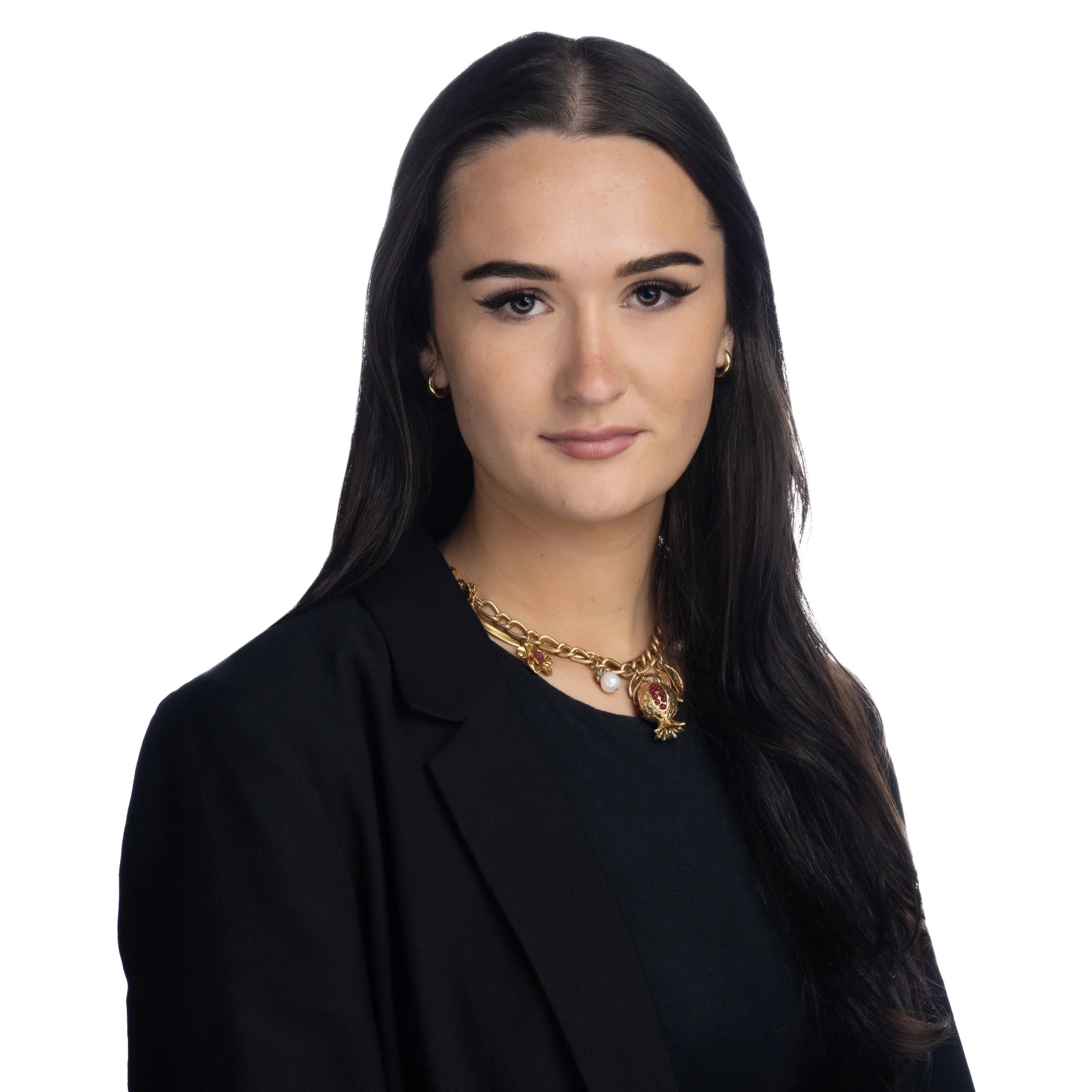 Woman with long dark hair wearing a black blazer and necklace, against a white background.