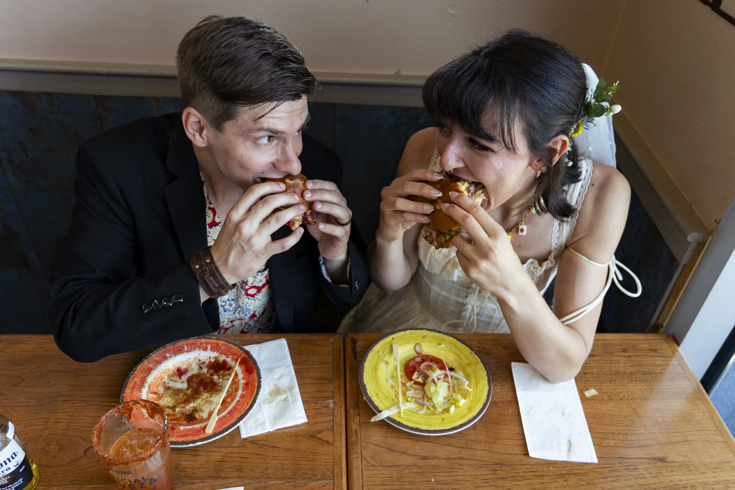A man and woman enjoying Mexican food together, eating tacos at a restaurant.