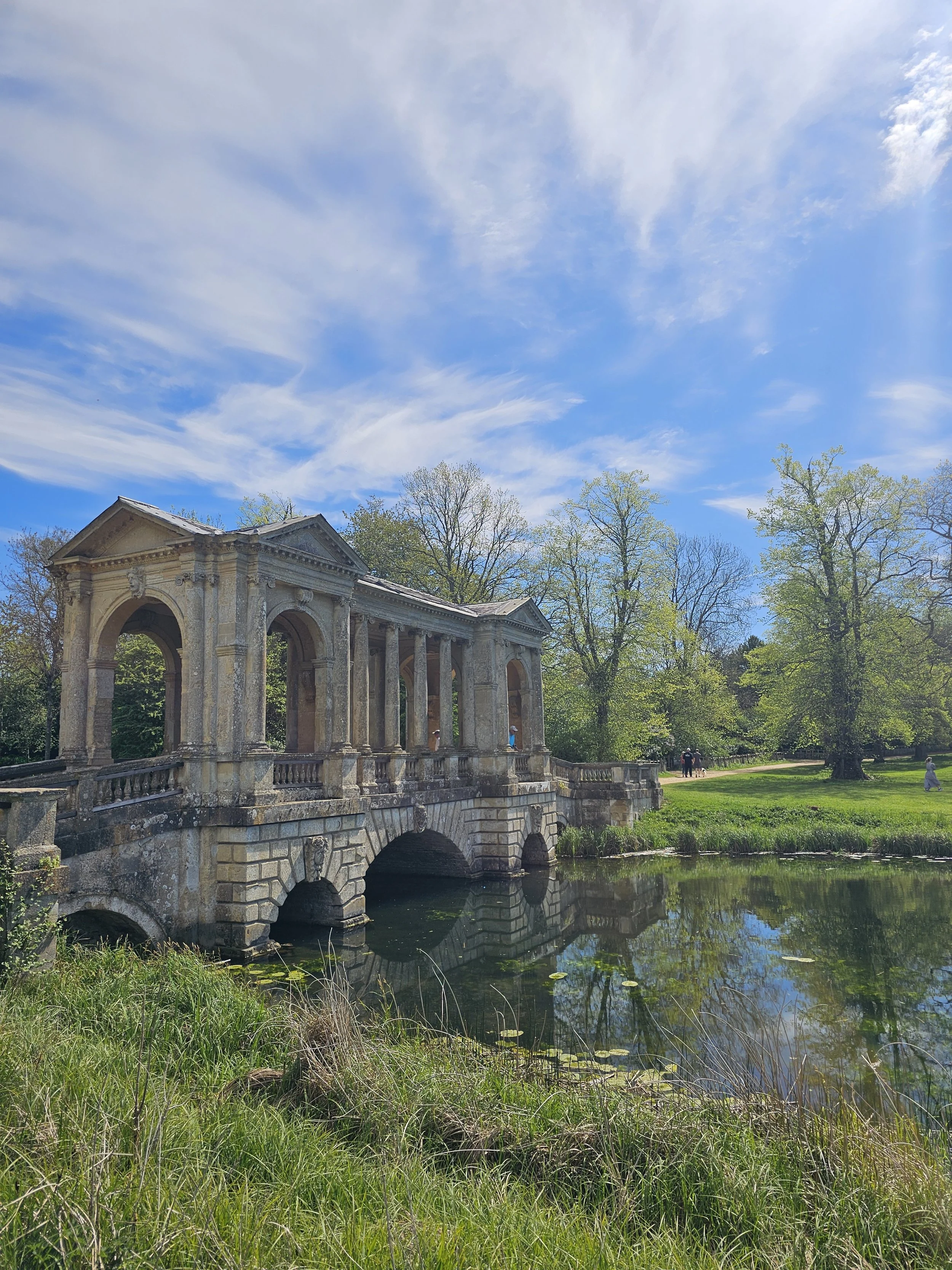 The glorious Palladian Bridge of Stowe landscape, set over the serpentine lake with trees with the first flush of leaves in the back ground.