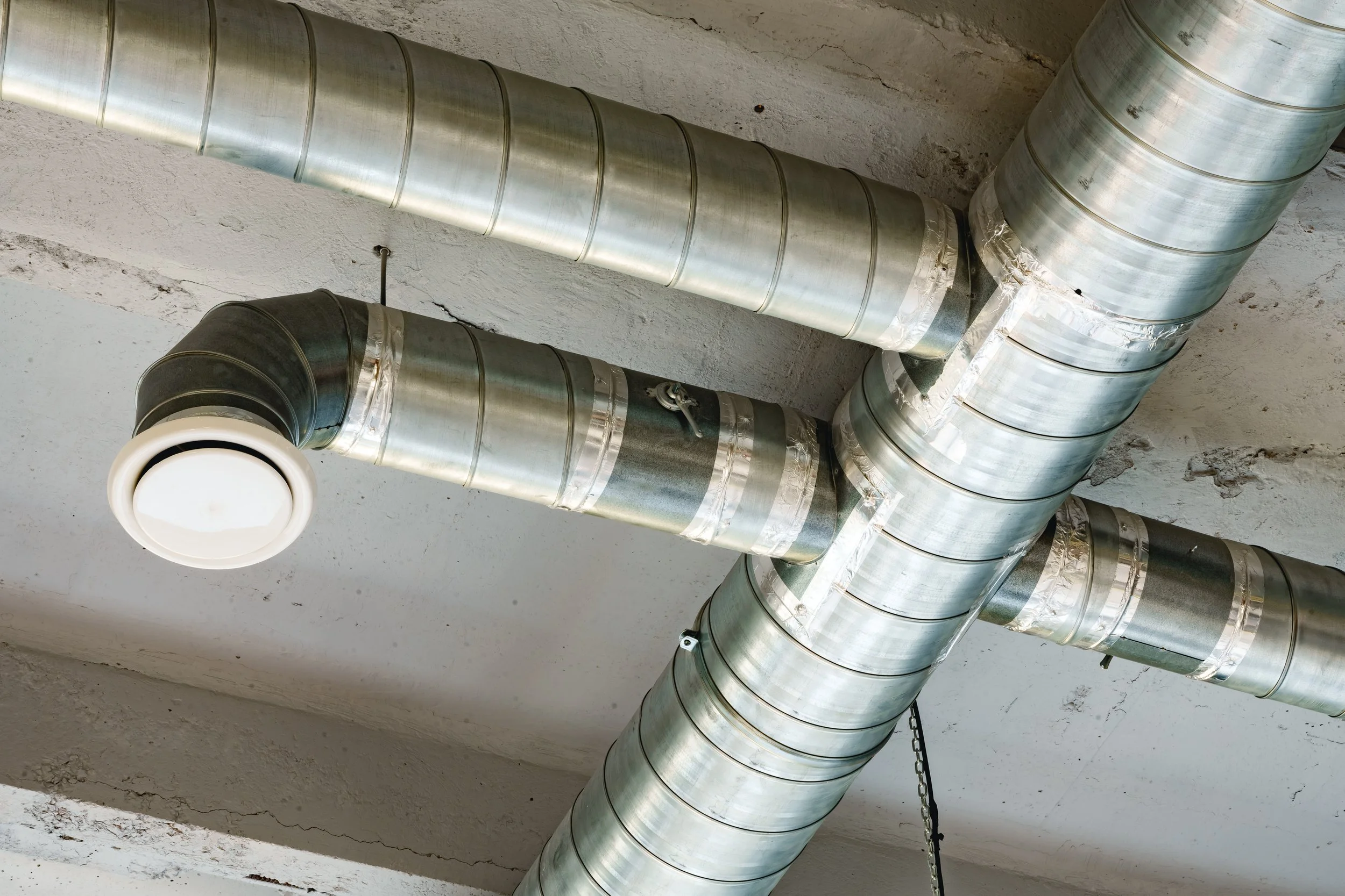 Industrial meta ductwork on a white ceiling