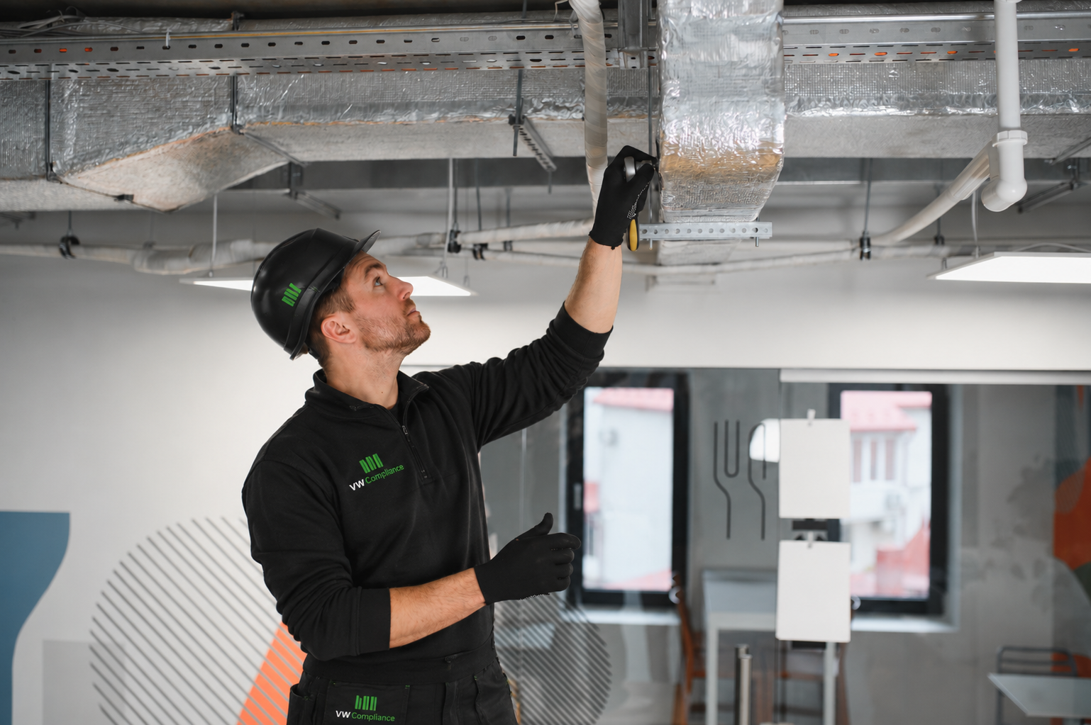 VW Compliance technician inspecting office ductwork and ventilation system