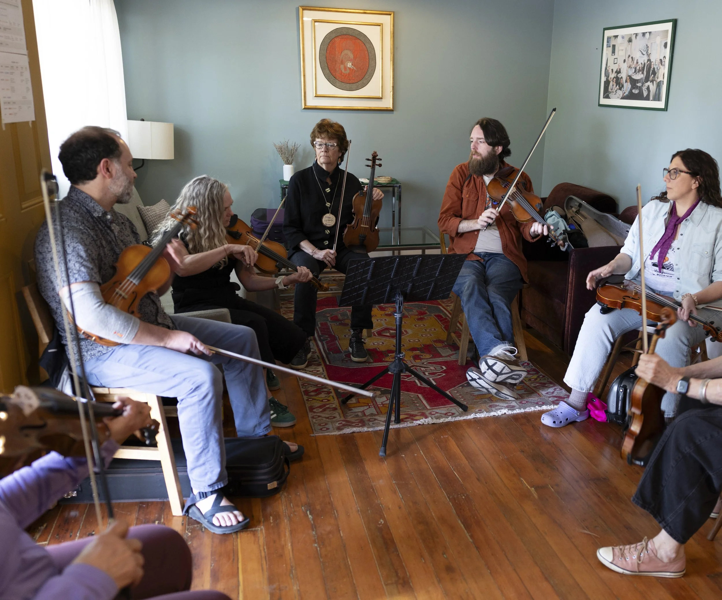 Musicians in a circle sitting in a cabin practicing