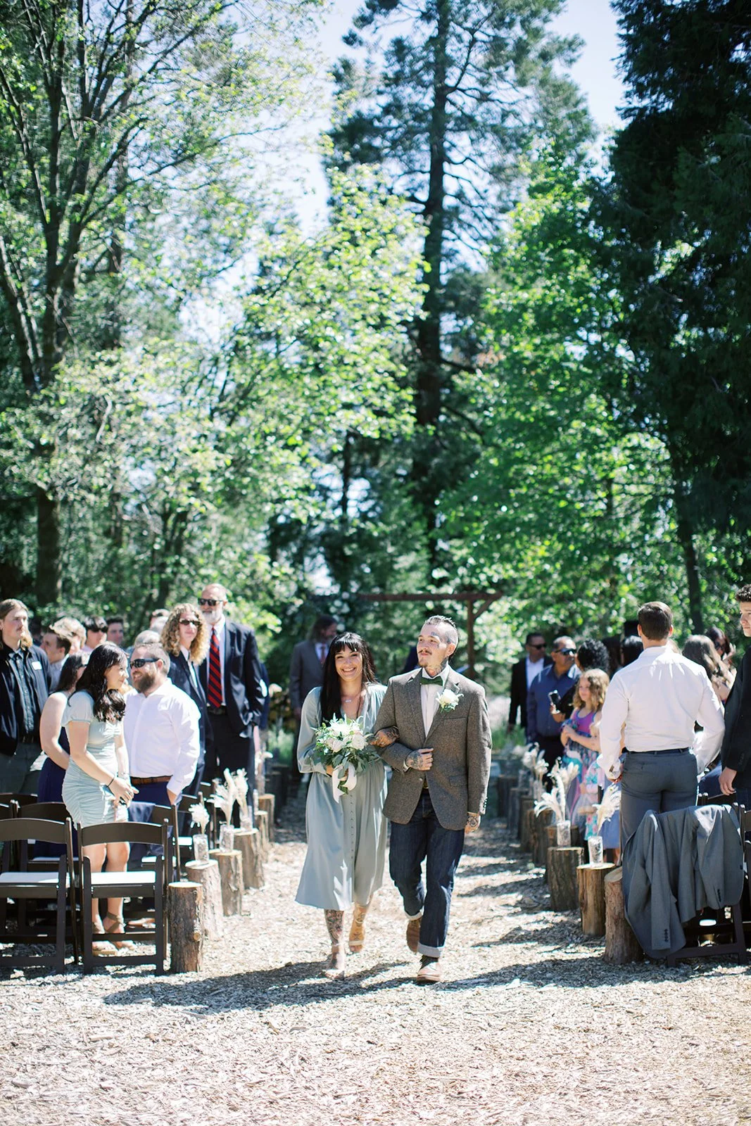 People walking down the aisle at wedding reception in the woods