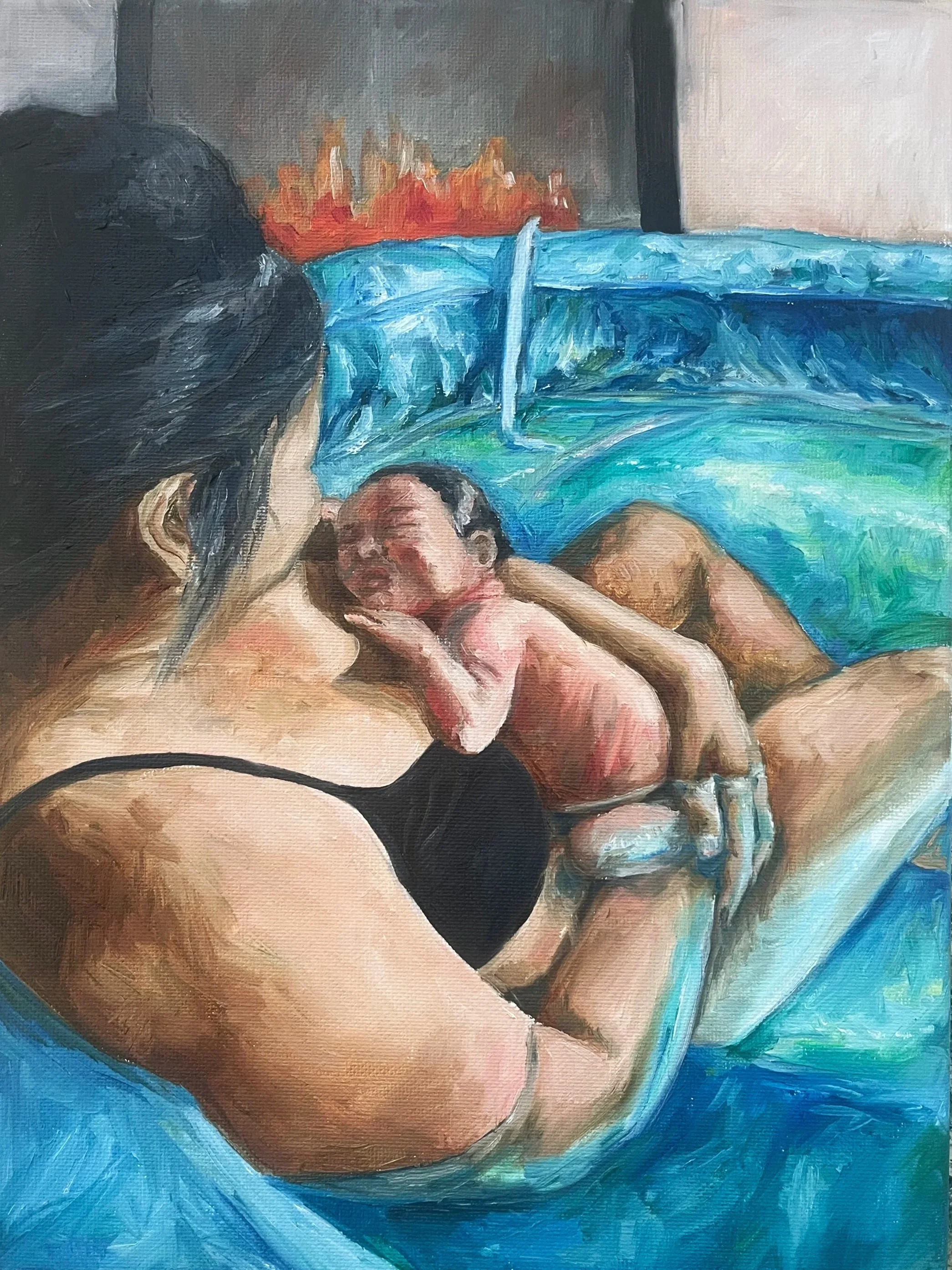A woman with dark hair holding a newborn baby, both lying on a surface with a blue sheet. The background has a painting or image of red and orange flames.