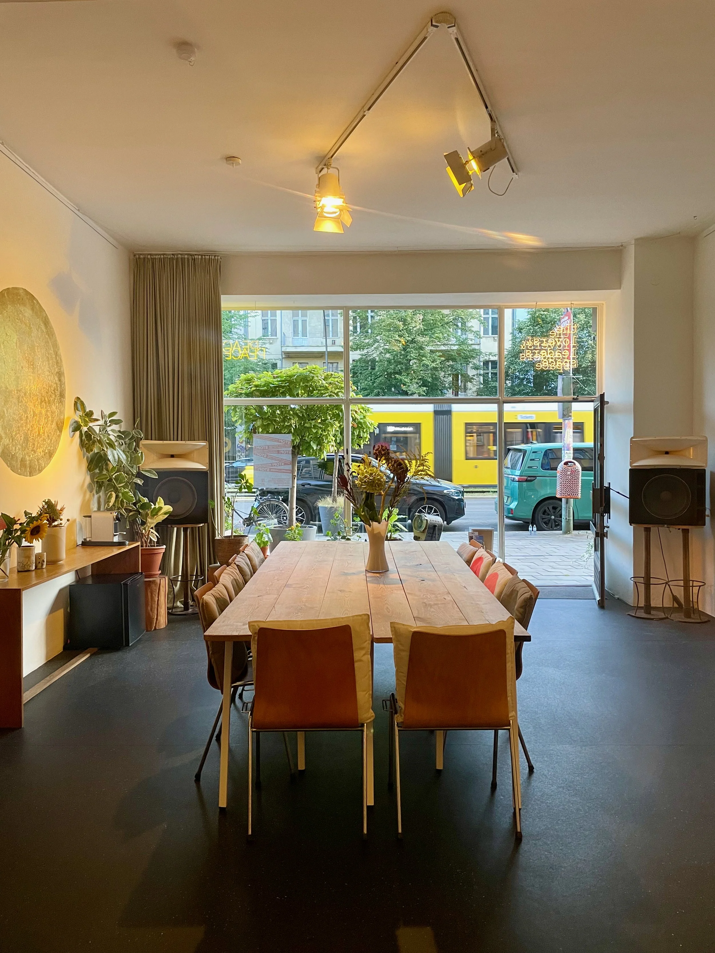 Großer heller Raum mit schönen handgemachten Möbeln und Pflanzen mit Blick auf eine belebte Straße in Berlin