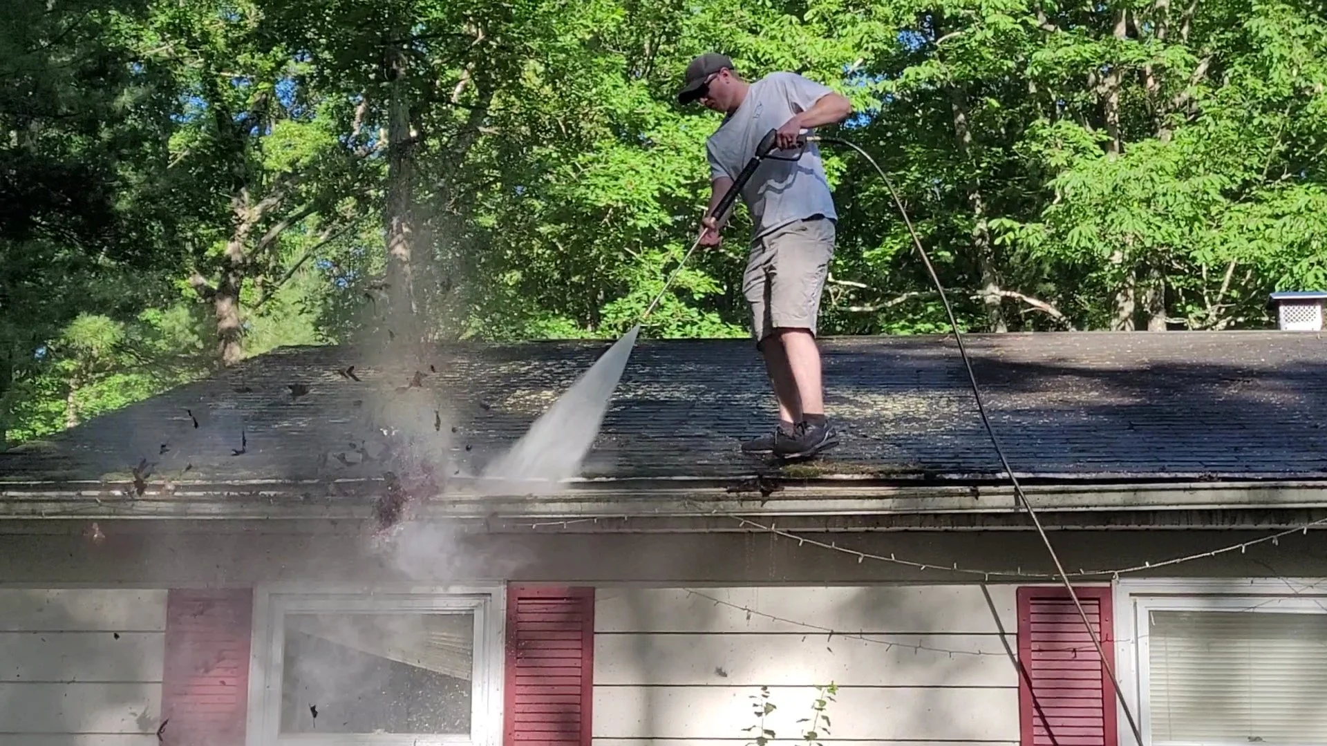 Man power washing the roof of a house