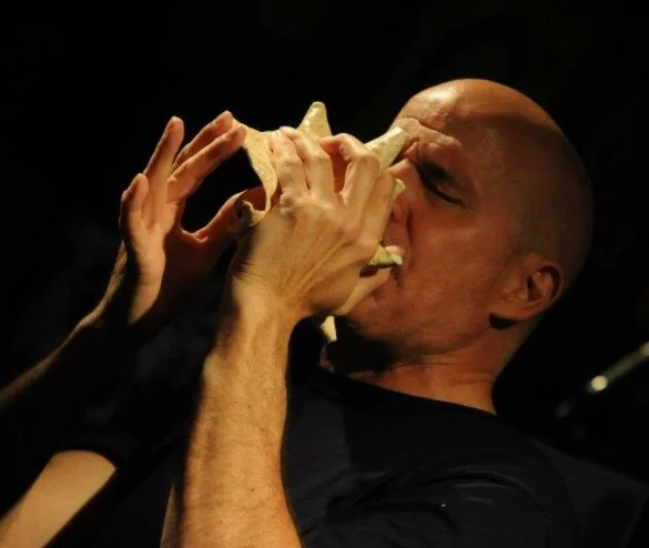 John playing conch shell