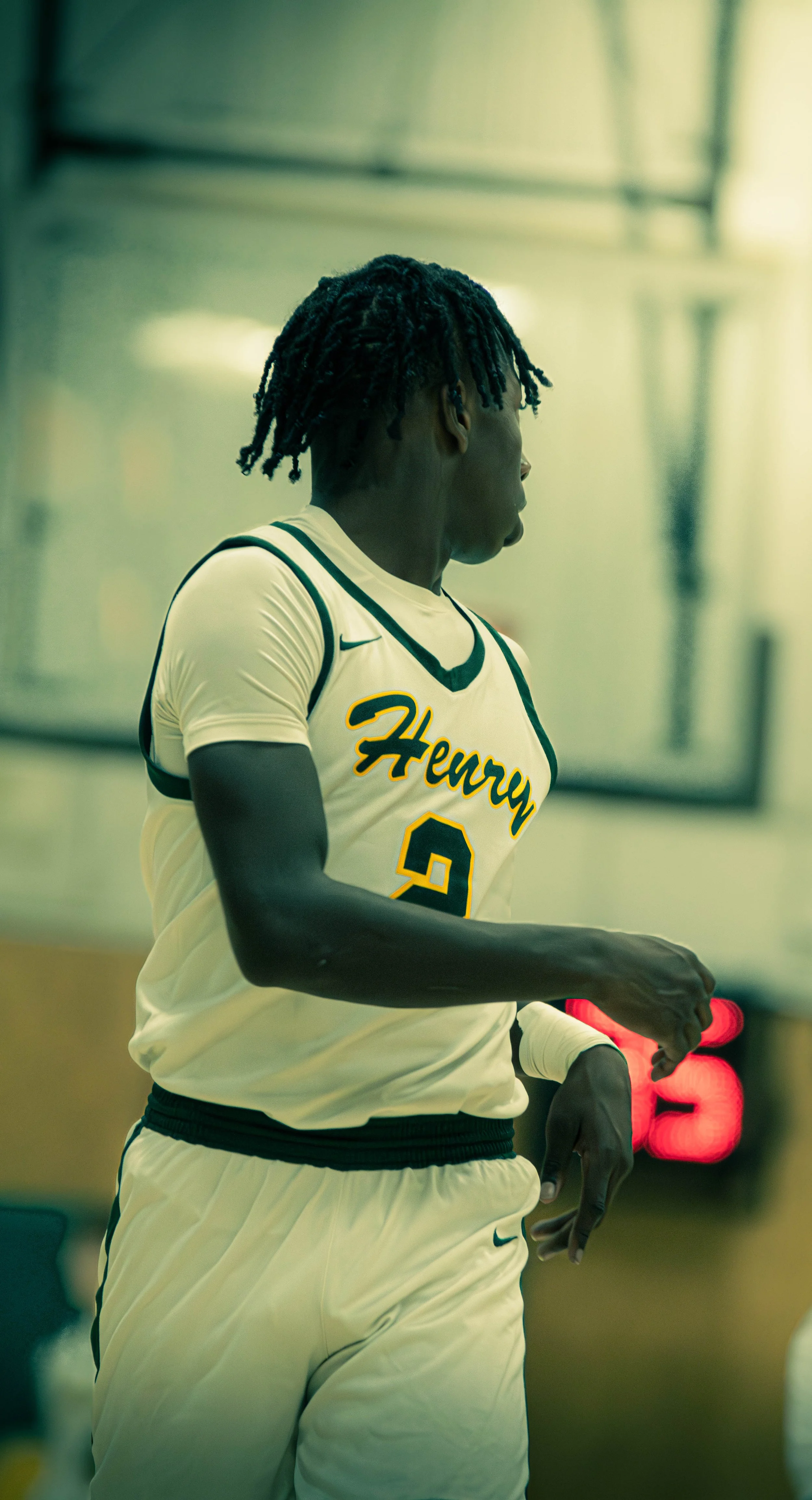 A male basketball player wearing a white jersey with 'Henry' written on it and the number 2, walking or running on the court.