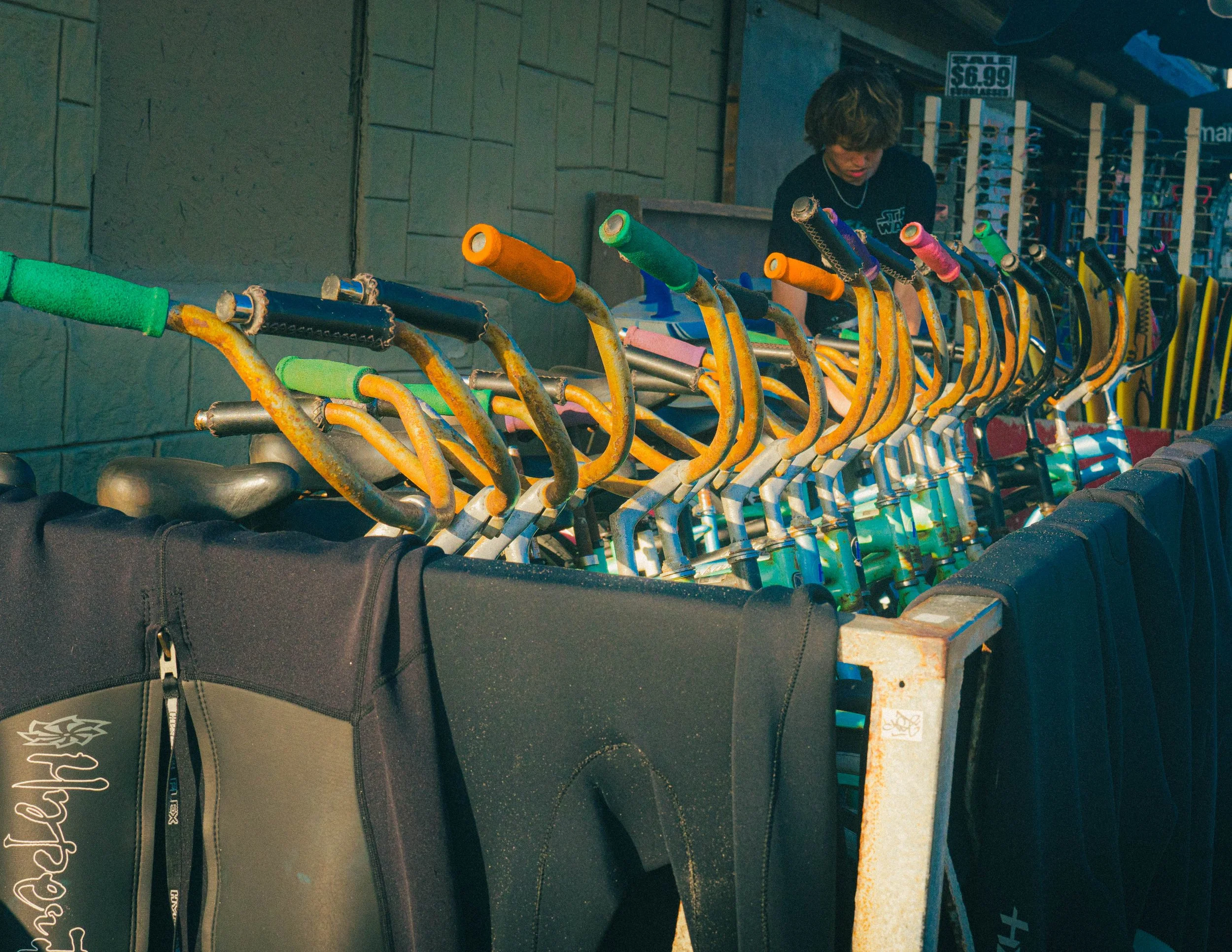 Colorful scooters lined up outside a store with a sale sign indicating a price of $6.99.