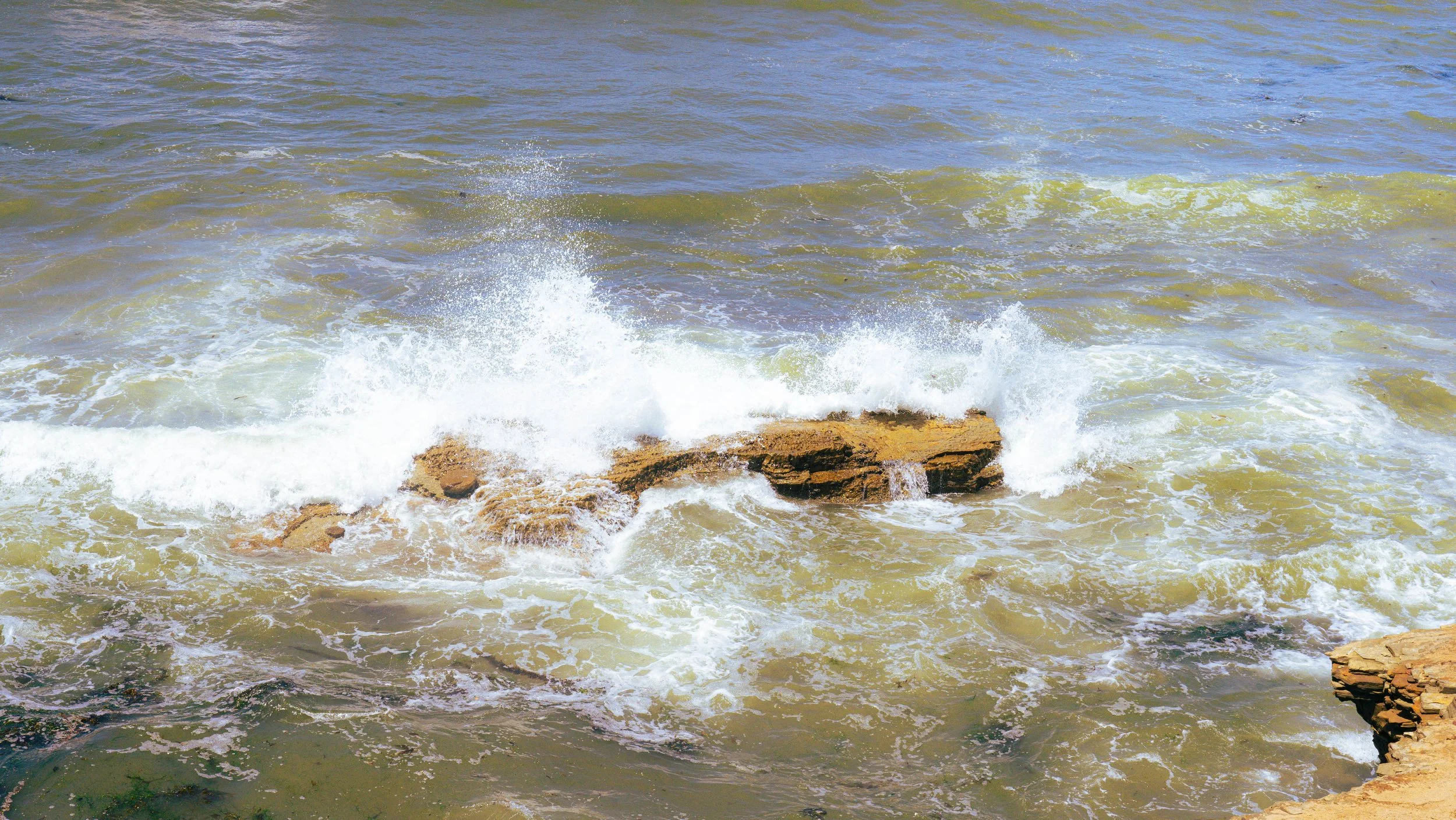 Waves crashing against rocks in the ocean.