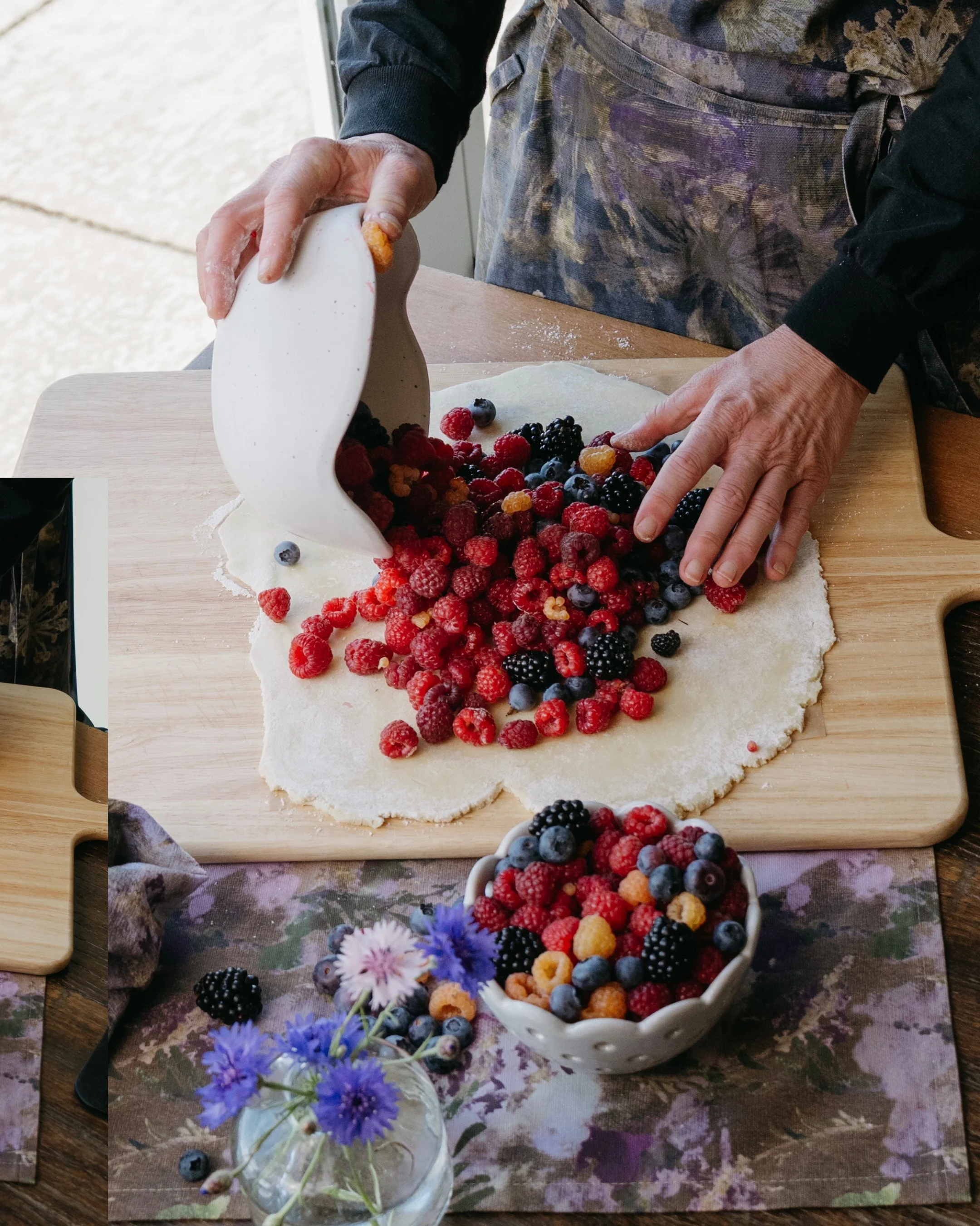 Snacky Girl wearing her signature apron, preparing a mixed berries galette on the Snacky Girl Snapdragon print.