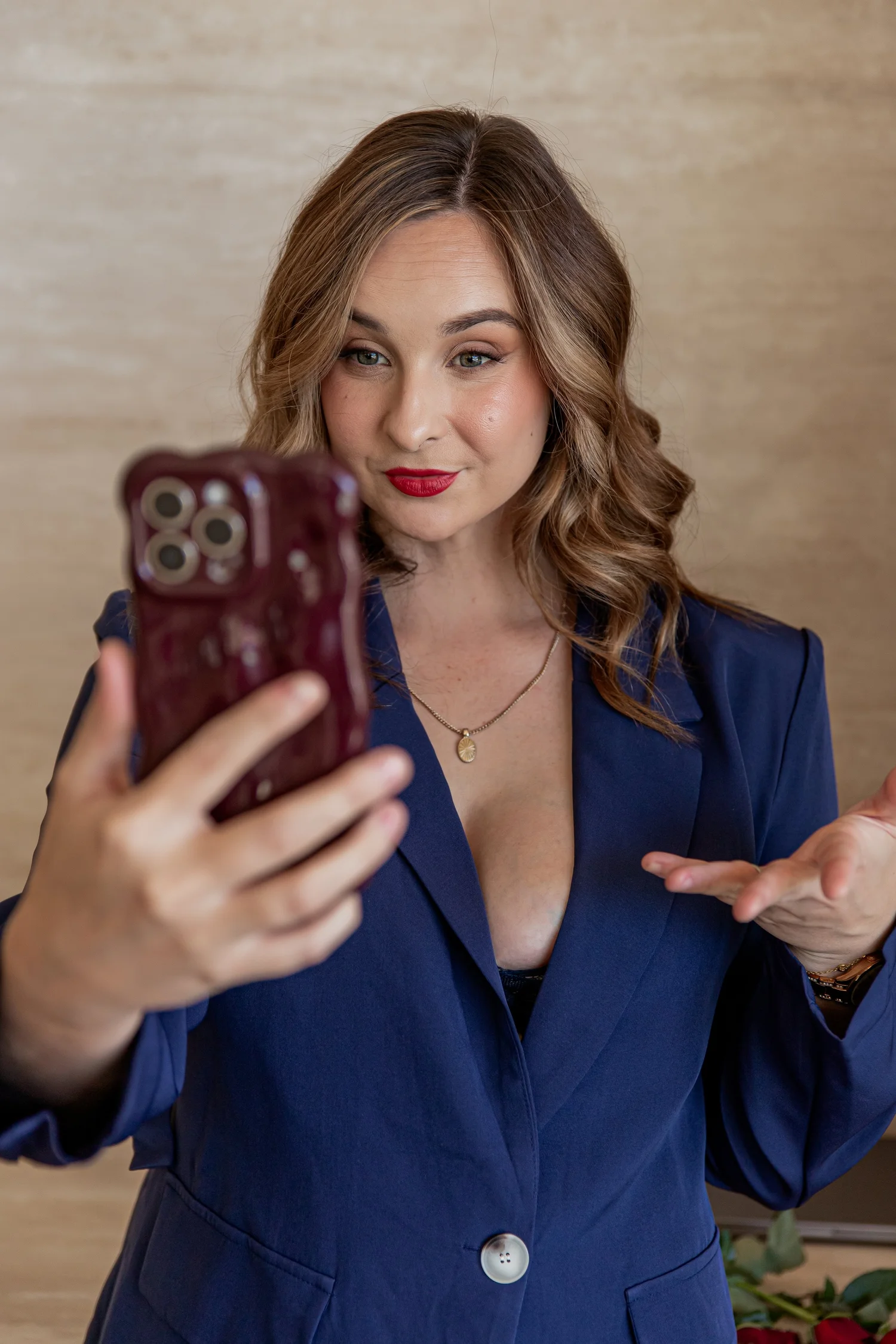 Cass in a navy suit, talking to camera on her phone