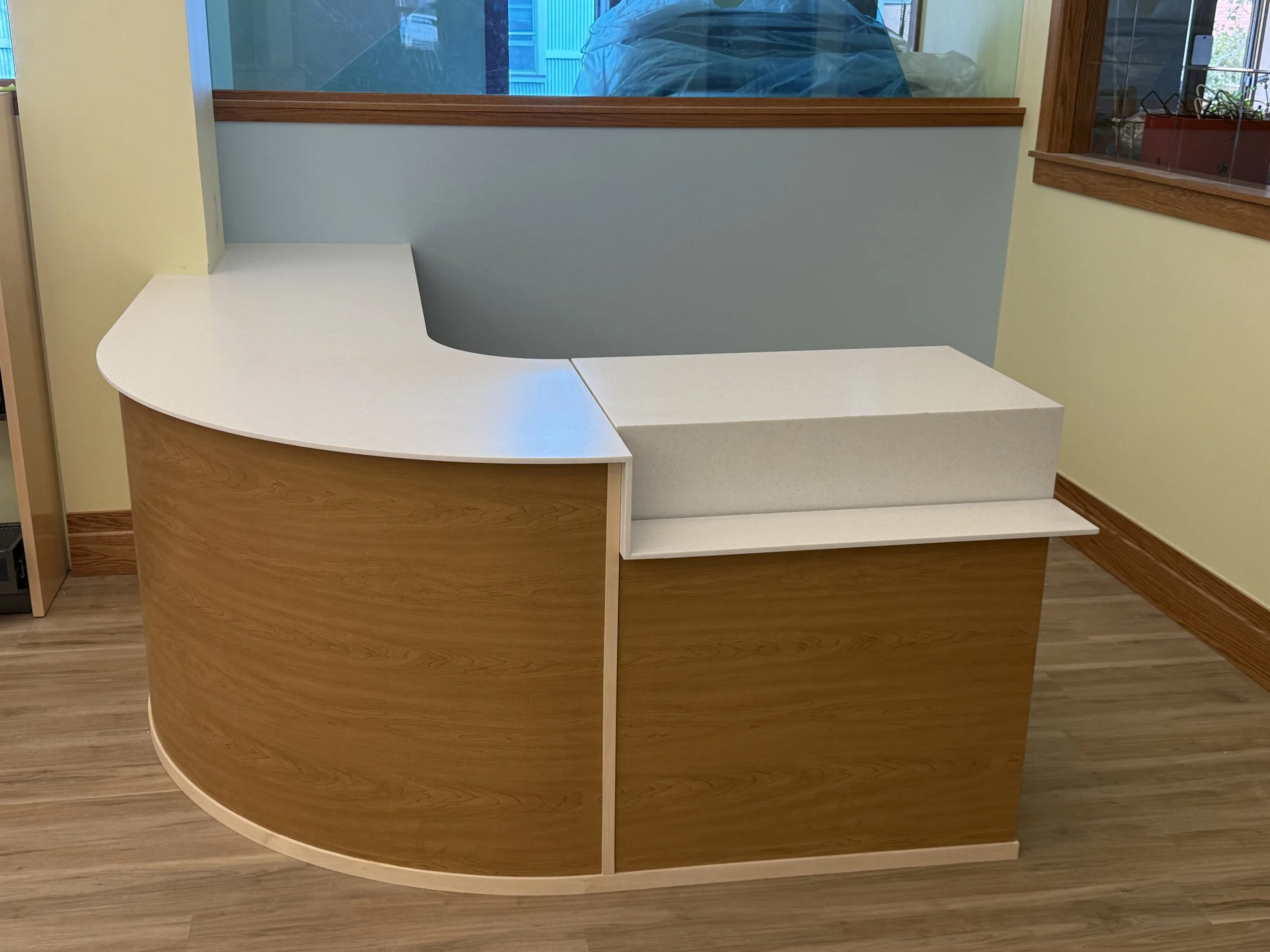 Circulation desk: Wilkinson Public Library, Telluride, CO. Curved maple desk with solid surface countertop and integrated standing desk