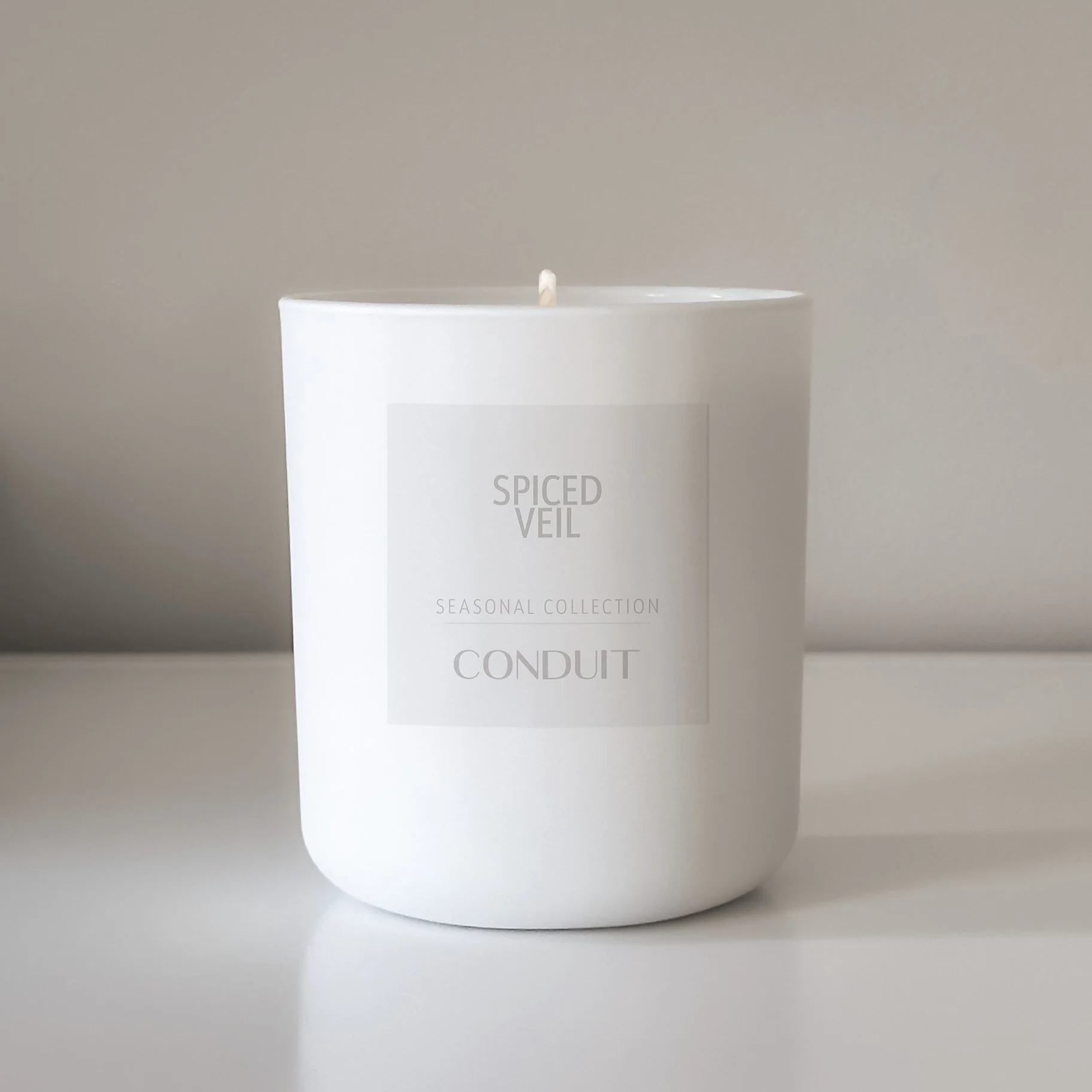 Spiced Veil candle in white glass.