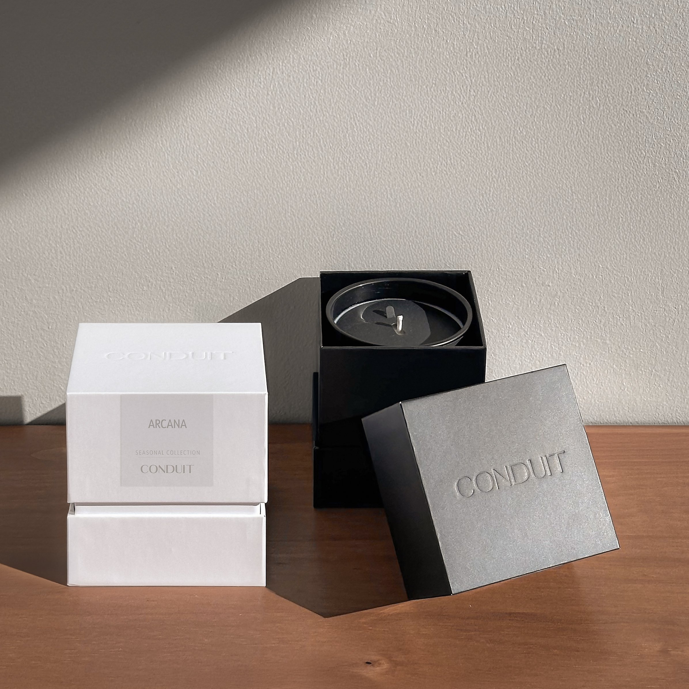 Arcana candle packaging in black and white minimalist box.