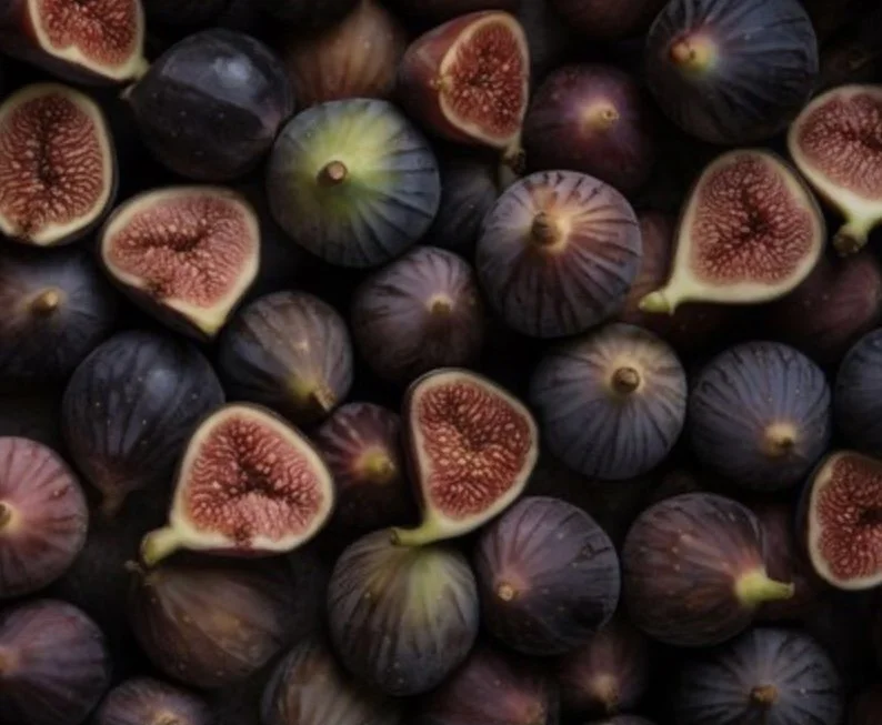 A pile of fresh figs, some sliced open showing red flesh and tiny seeds inside.