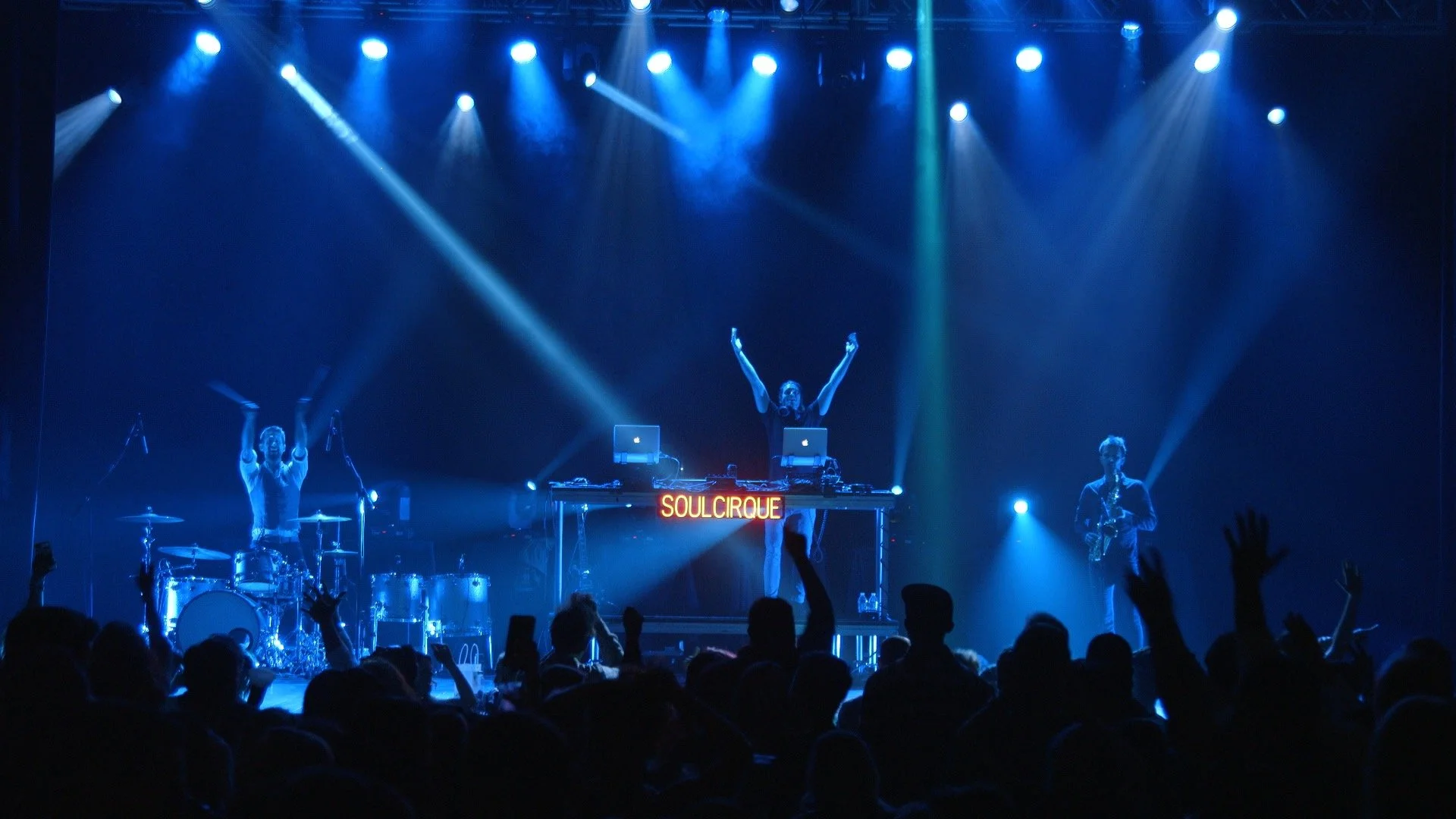 Live drummer and sax performing with DJ for a packed dance floor in Texas