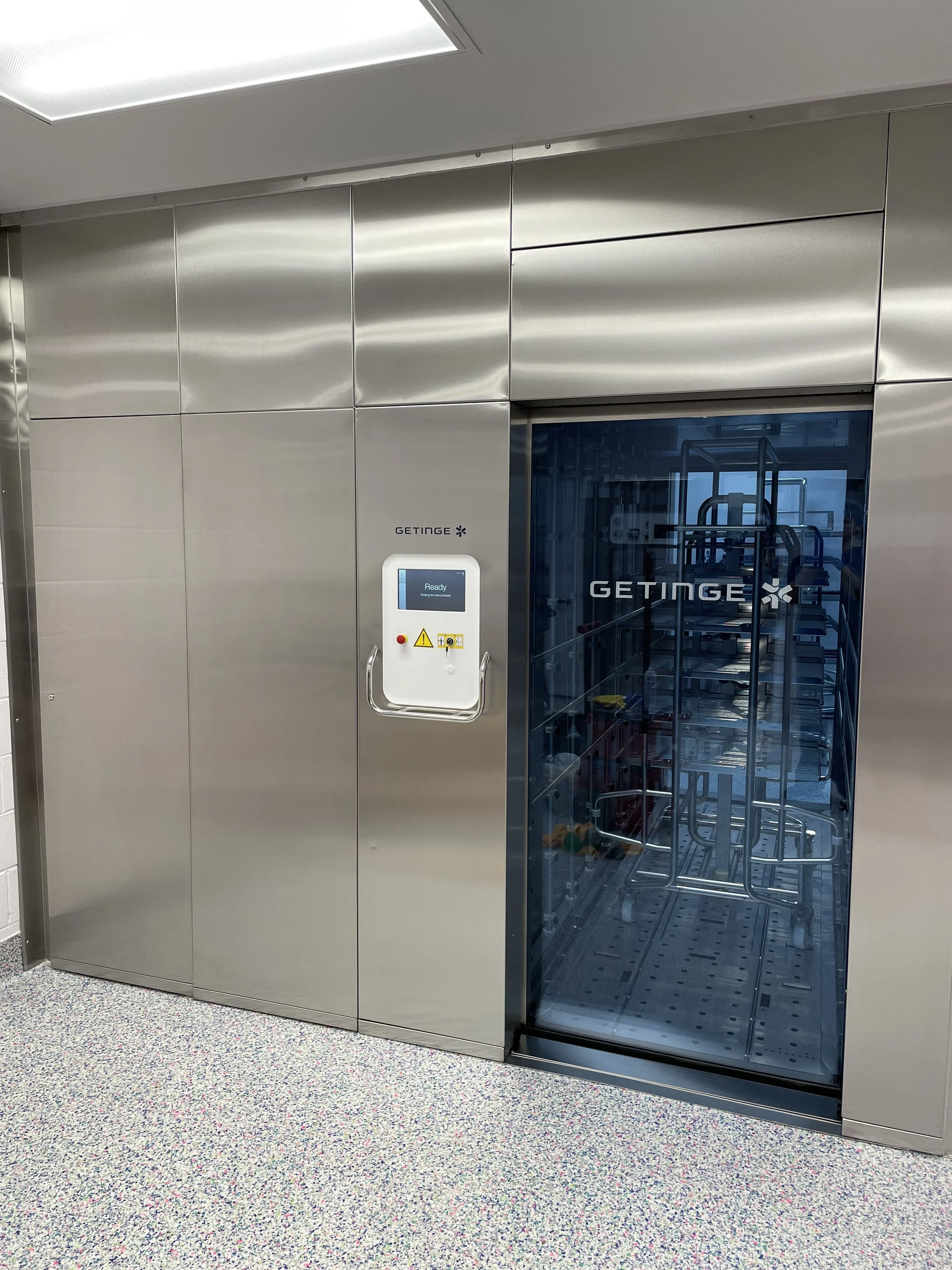 Getinge sterilizer with stainless stell exterior glass window/access, and white information display