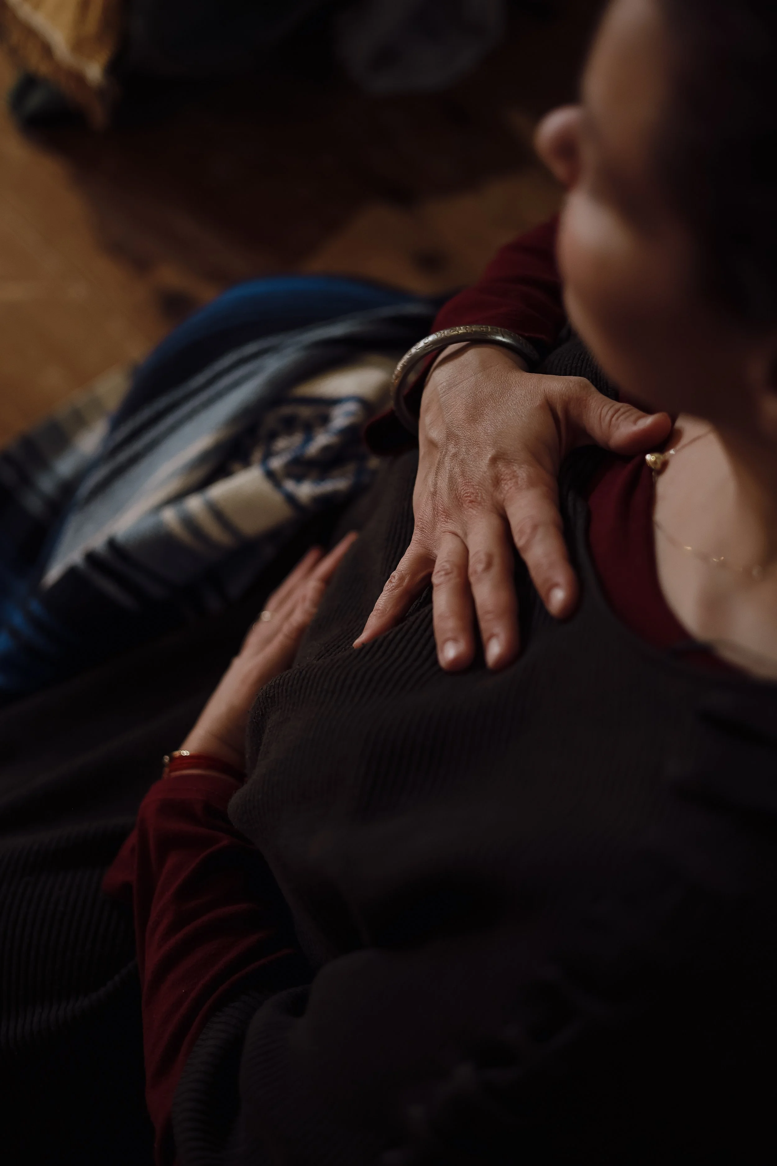 A woman meditating and holding her heart at a rest and reconnect retreat at the seed lodge.