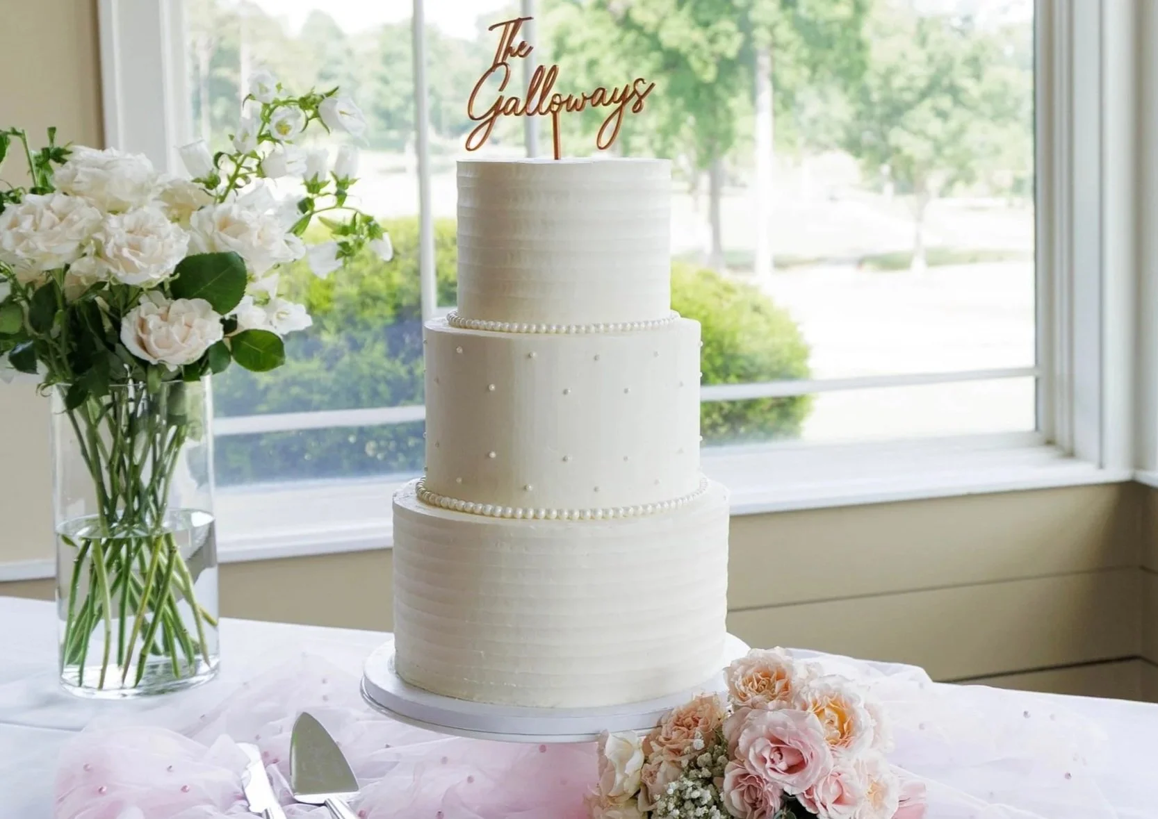 Classic 3 tier white wedding cake with dots in the middle tier