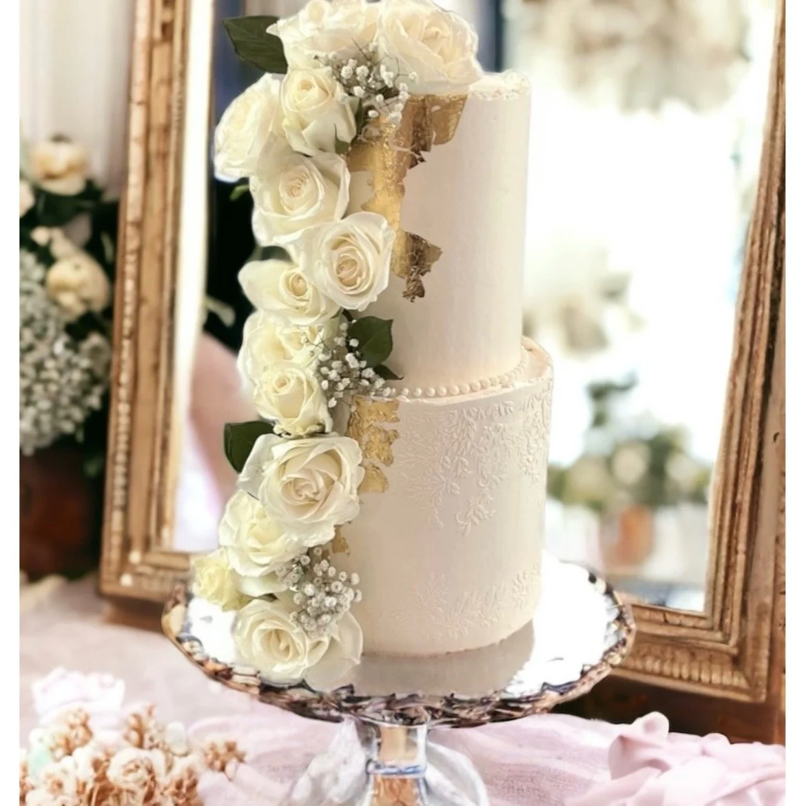 Tall 2 tier wedding cake with gold leaf applique and white roses