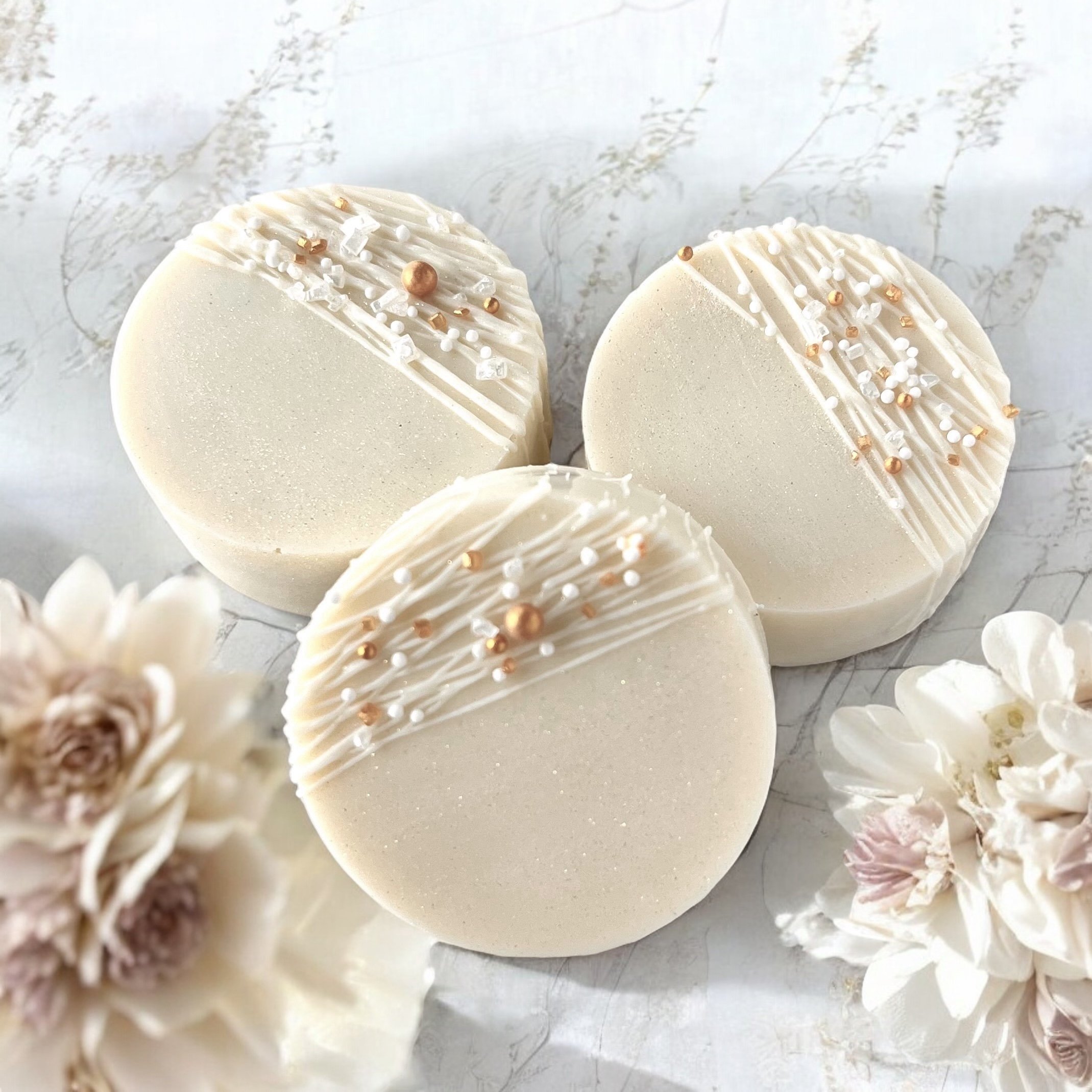 Chocolate covered oreos with chocolate drizzle and white and gold sprinkles